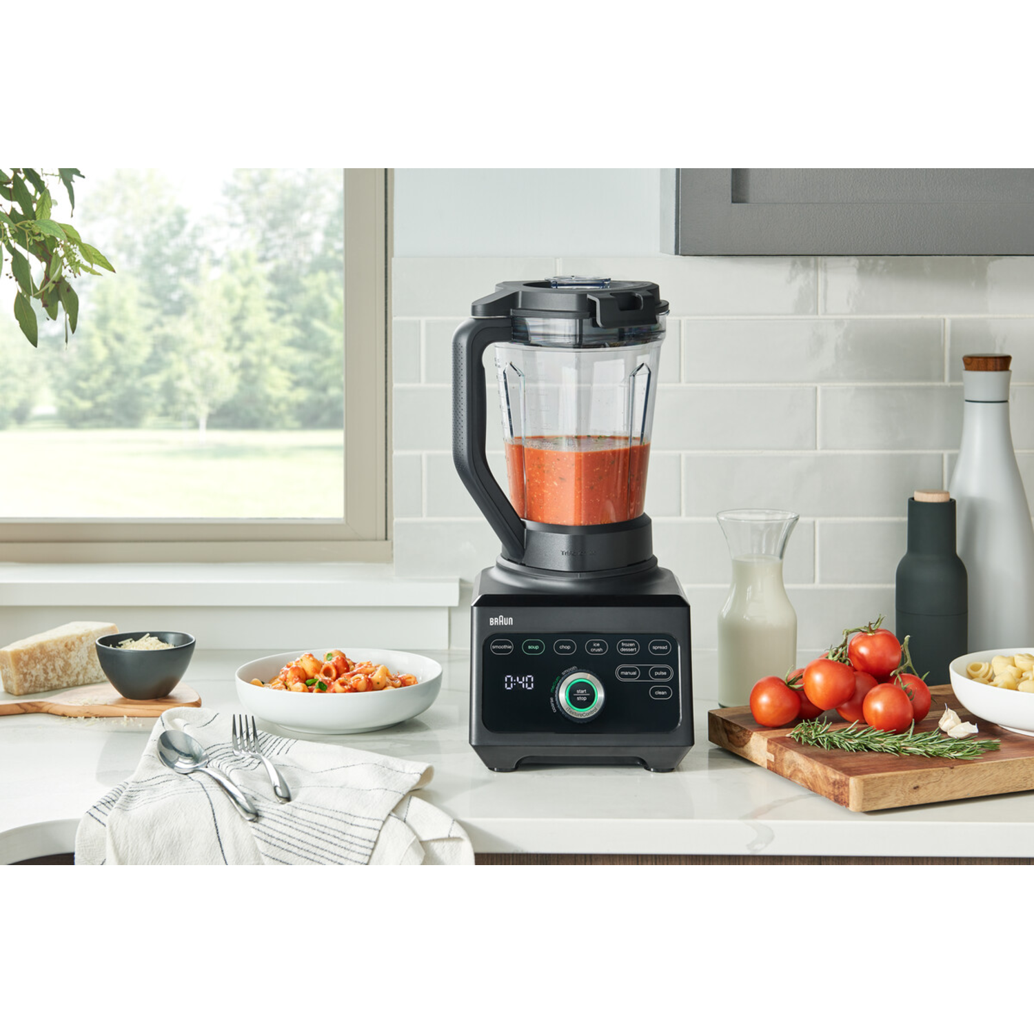 Blender with soup, tomatoes, pasta, and ingredients.