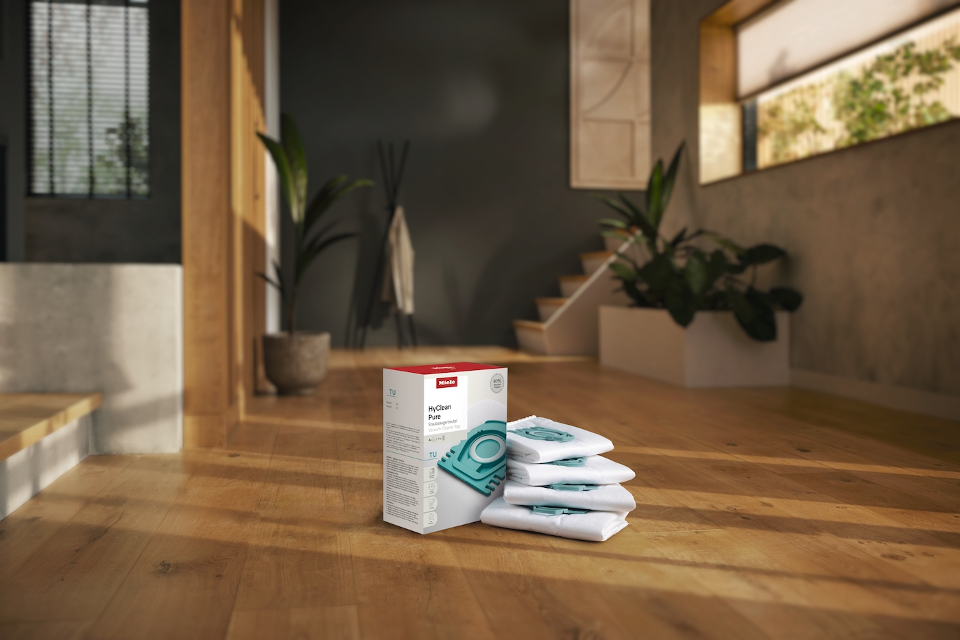 Ein Miele HyClean Staubsaugerbeutel-Karton und Staubsaugerfilter auf Holzboden.