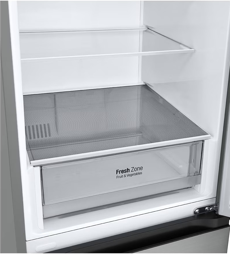 Zbliżenie na wnętrze lodówki. Posiada szufladę 'Fresh Zone'.