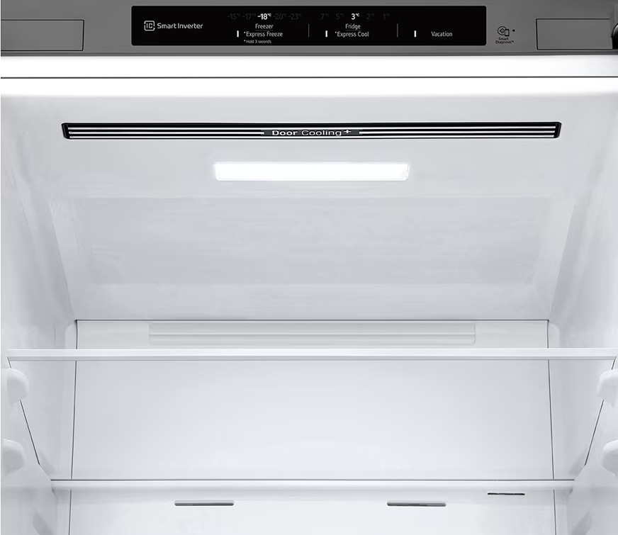 Wnętrze lodówki z półkami, światłem i elementami sterującymi. Elementy sterujące znajdują się na górze.