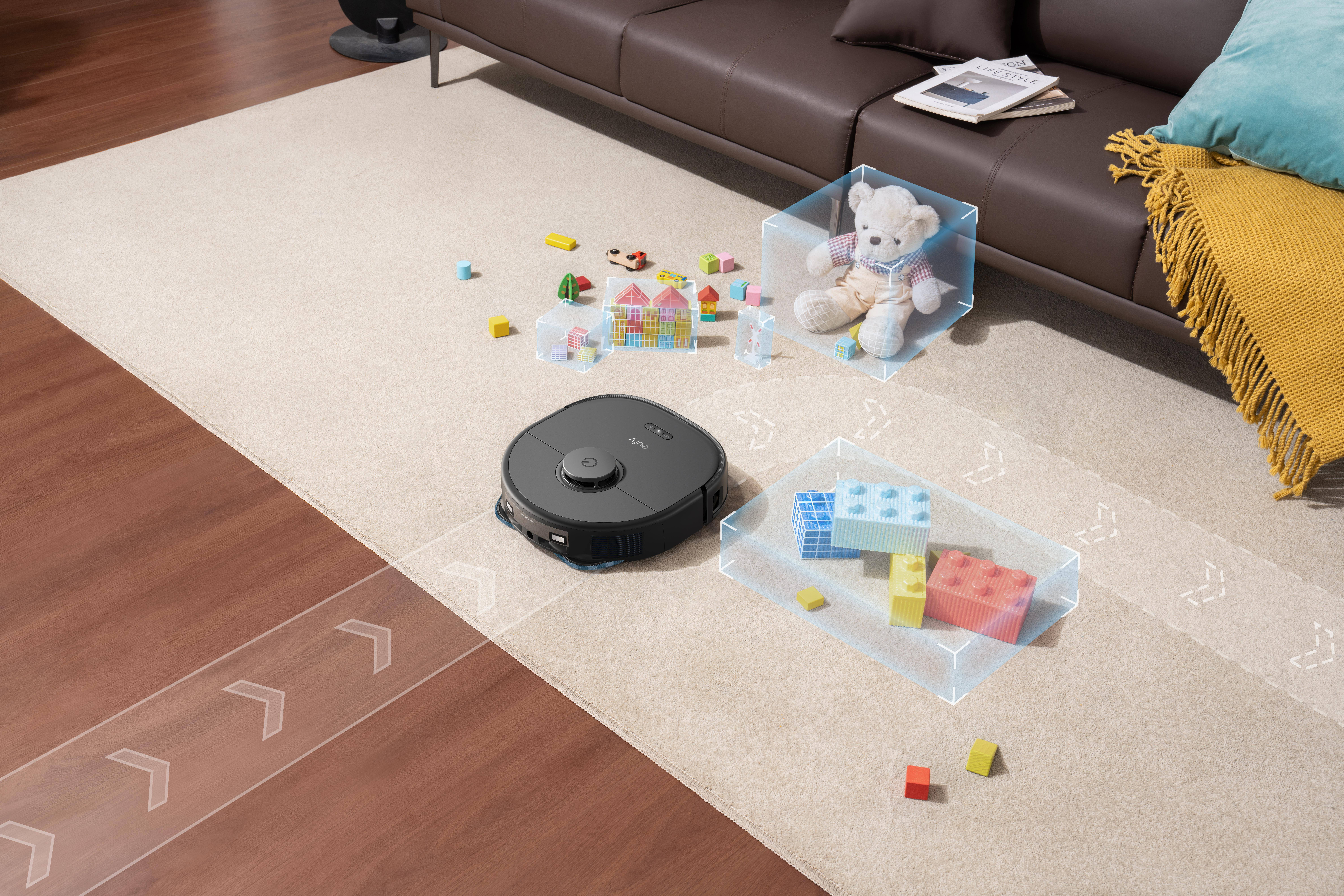 Ein Roboterstaubsauger auf einem beigefarbenen Teppich mit Spielzeug und Möbeln, ein Teddybär im Hintergrund.