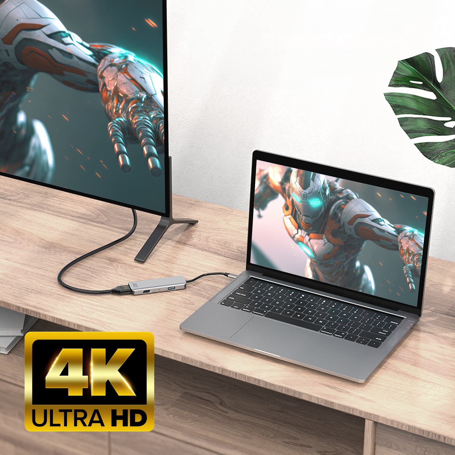 Laptop connected to a monitor with a hub. The screen shows a 4K ULTRA HD logo. The scene is well-lit.