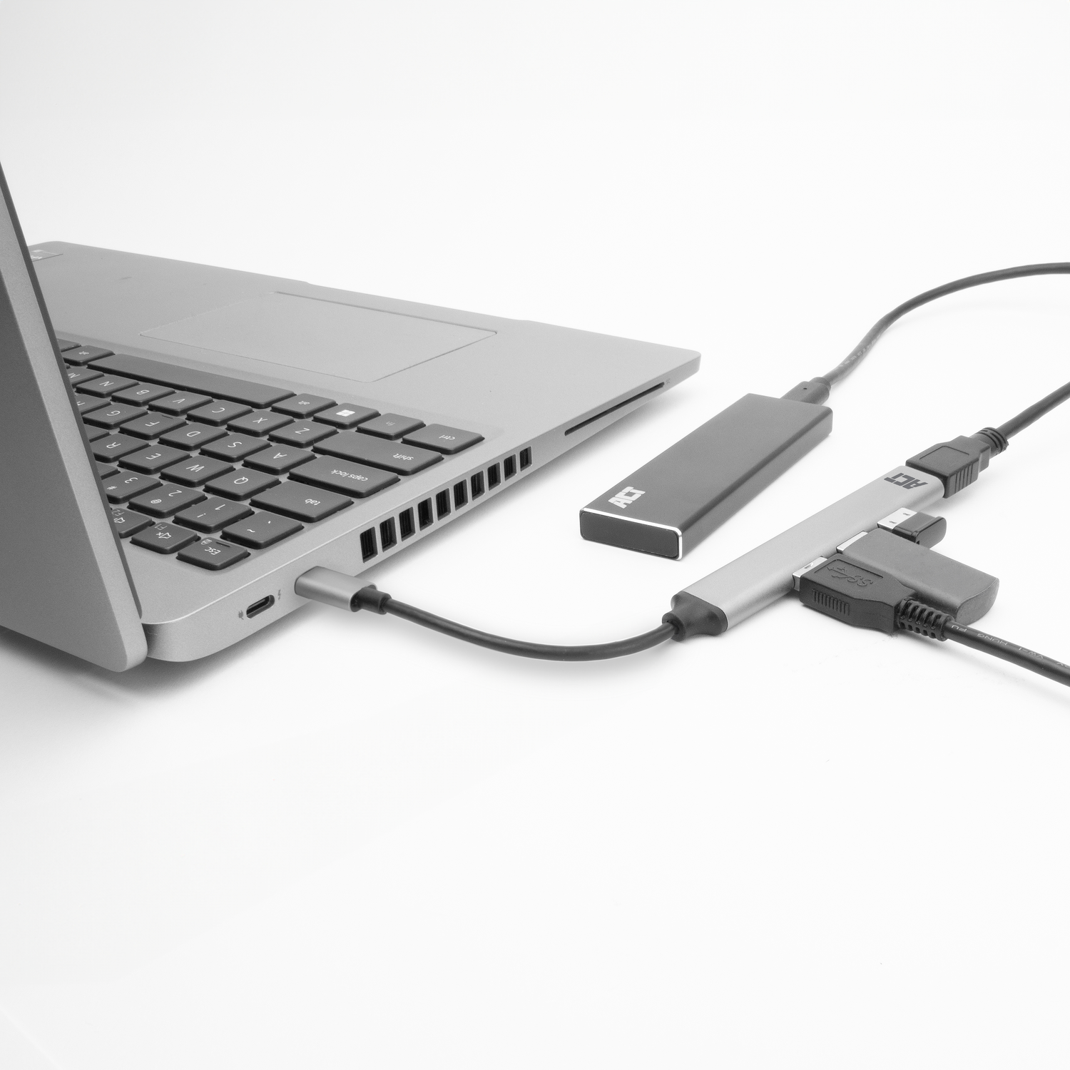 Laptop connected to a hub with multiple cables. White background.