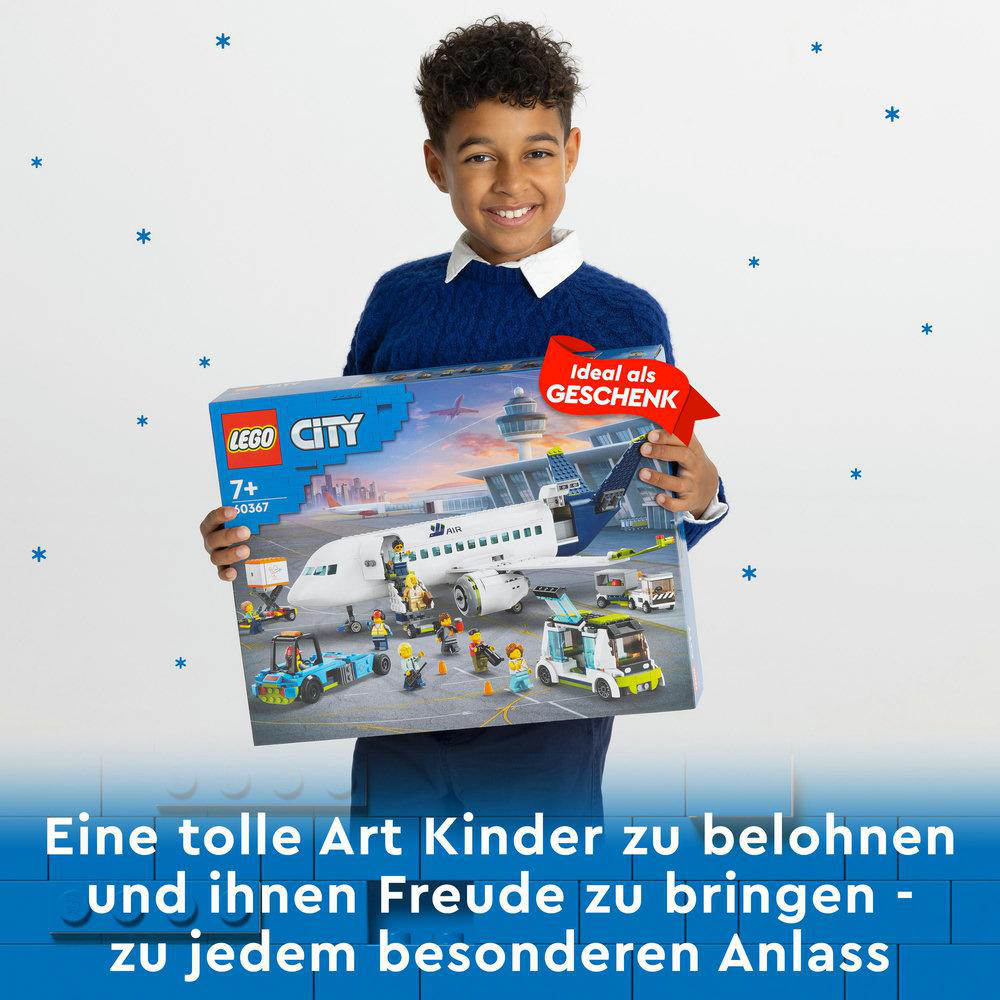 Ein Junge hält ein Lego City-Set mit einem Flugzeug darauf. Der Hintergrund ist hellblau mit Sternen.