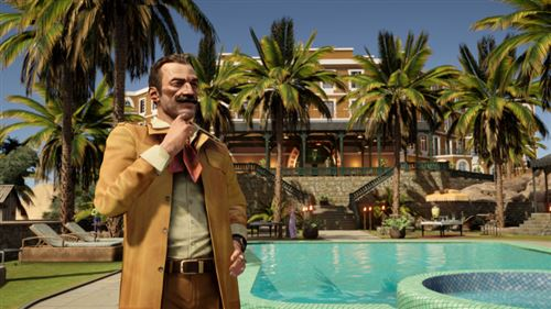Un hombre de pie junto a una piscina, palmeras y un edificio al fondo. Lleva un abrigo beige.