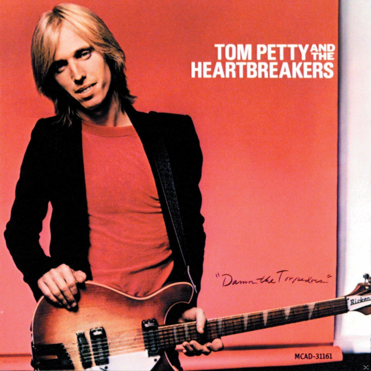 Albumcover von Tom Petty and the Heartbreakers. Tom Petty mit Gitarre, roter Hintergrund.