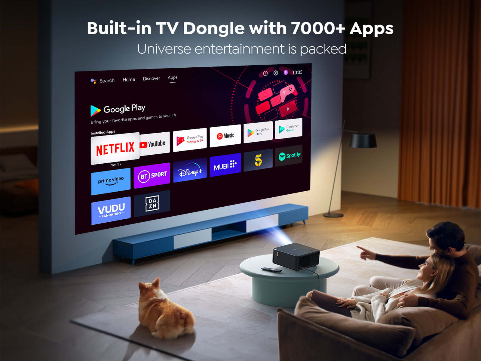 Bir çift büyük bir TV ekranını izliyor. Yakında bir köpek oturuyor. Ekran Google Play'i gösteriyor.