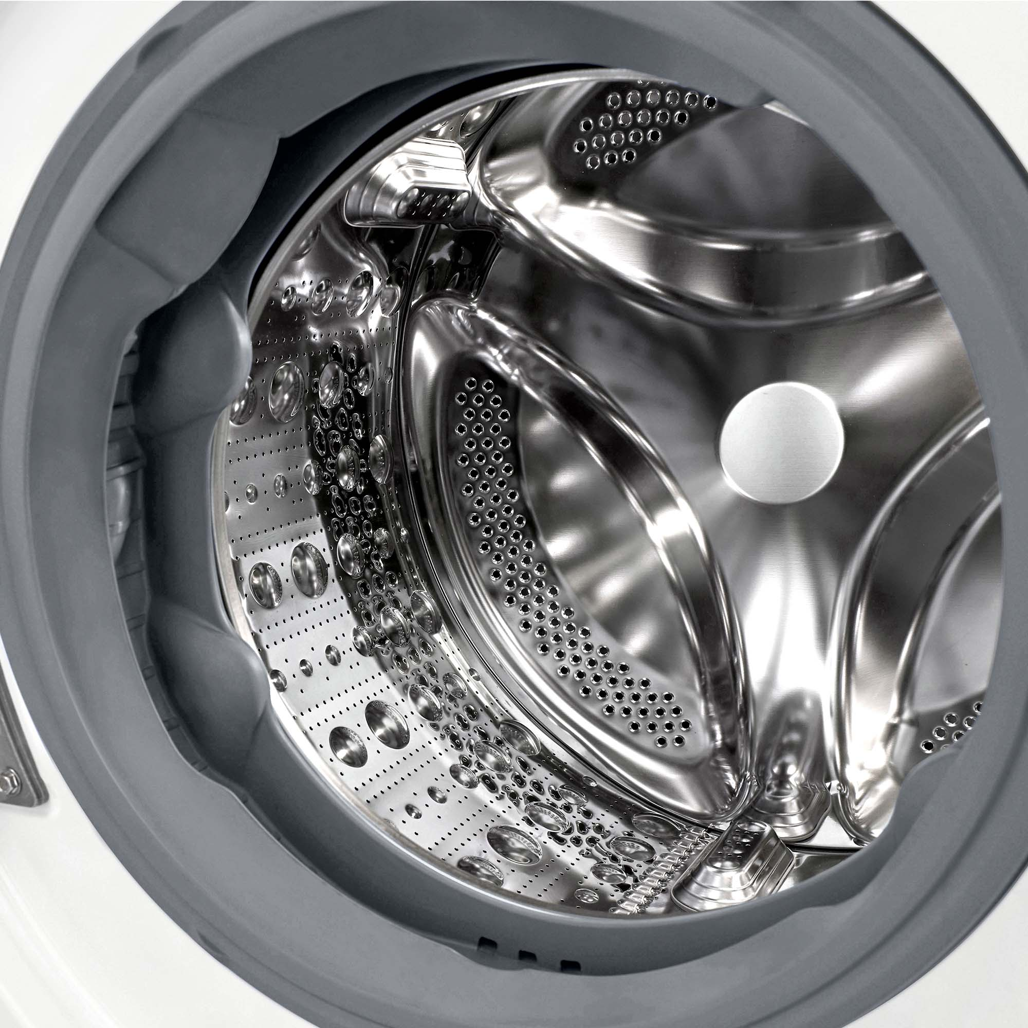 Primer plano del interior de una lavadora. Es de acero inoxidable. El fondo es blanco.