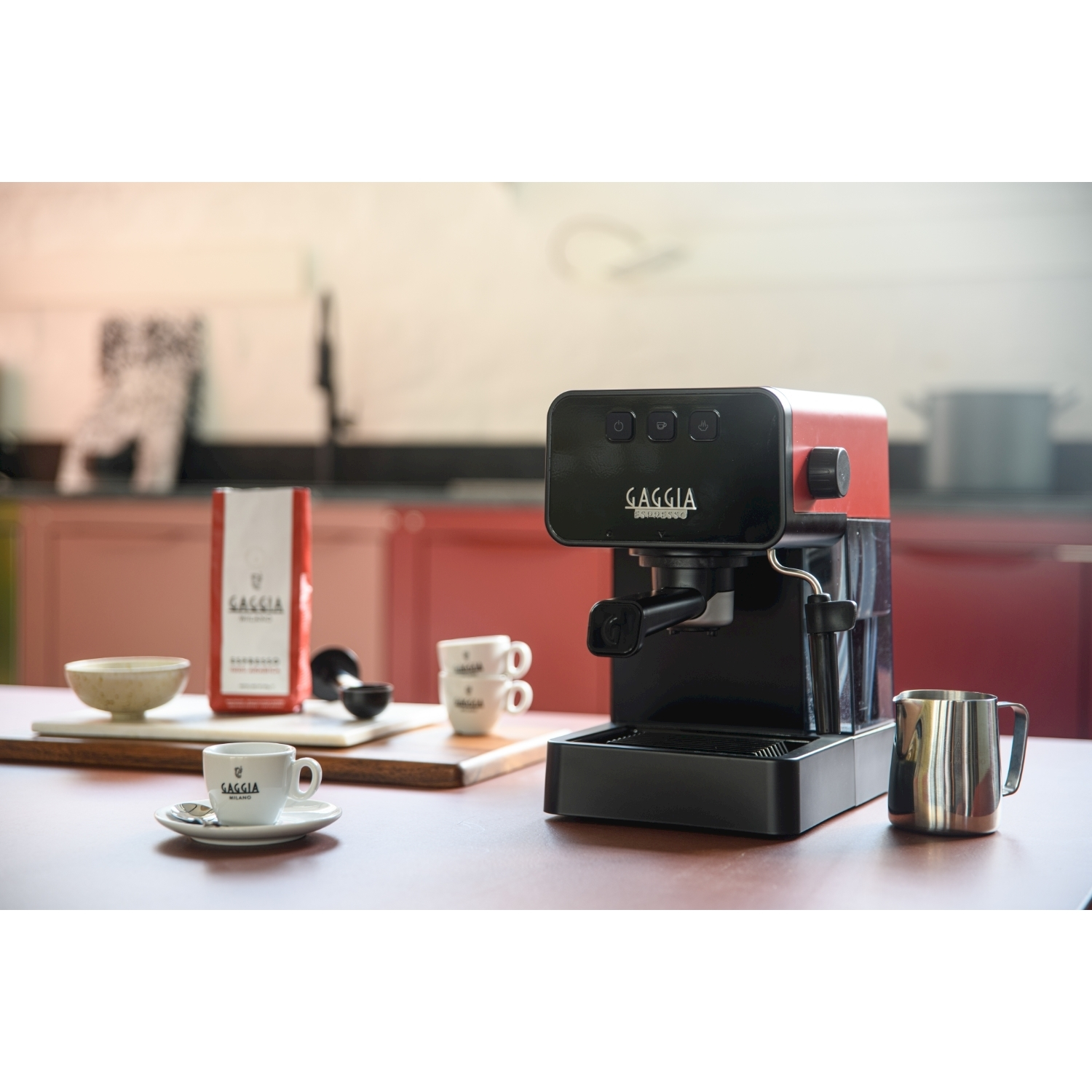 Macchina per espresso Gaggia rossa e nera con tazza e accessori.