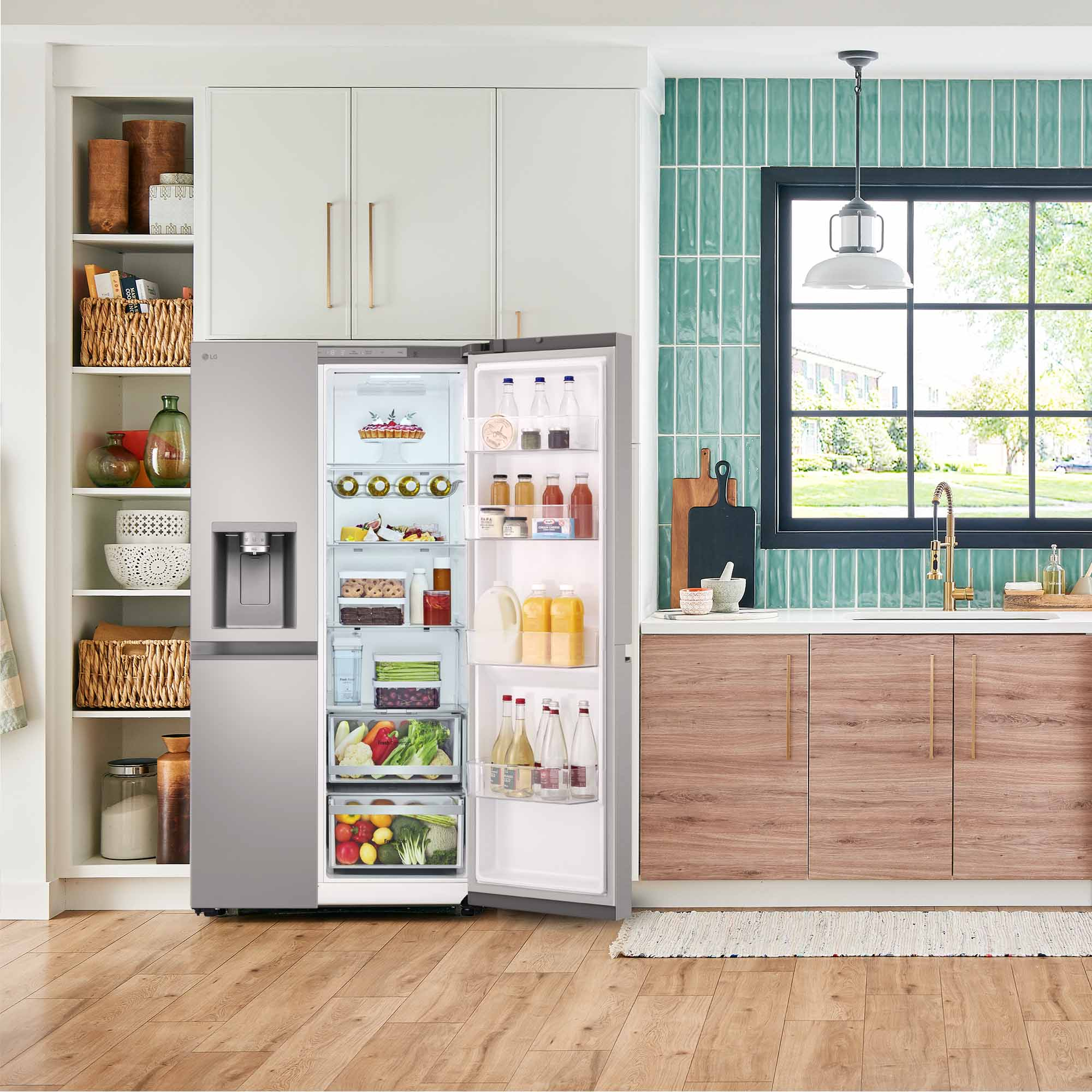 Un refrigerador con puertas abiertas, lleno de comida, en una cocina con gabinetes de madera y blancos.
