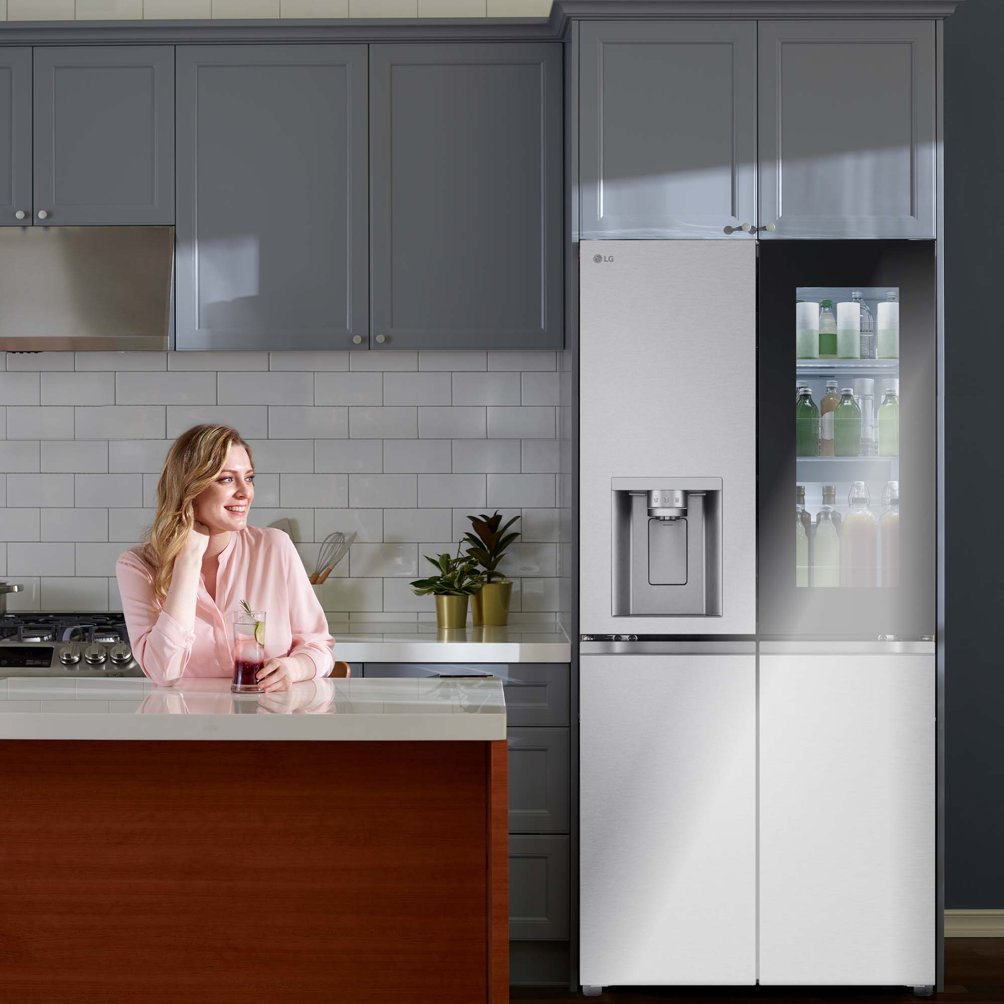 Mujer en una cocina con un refrigerador LG con diseño InstaView Door-in-Door.