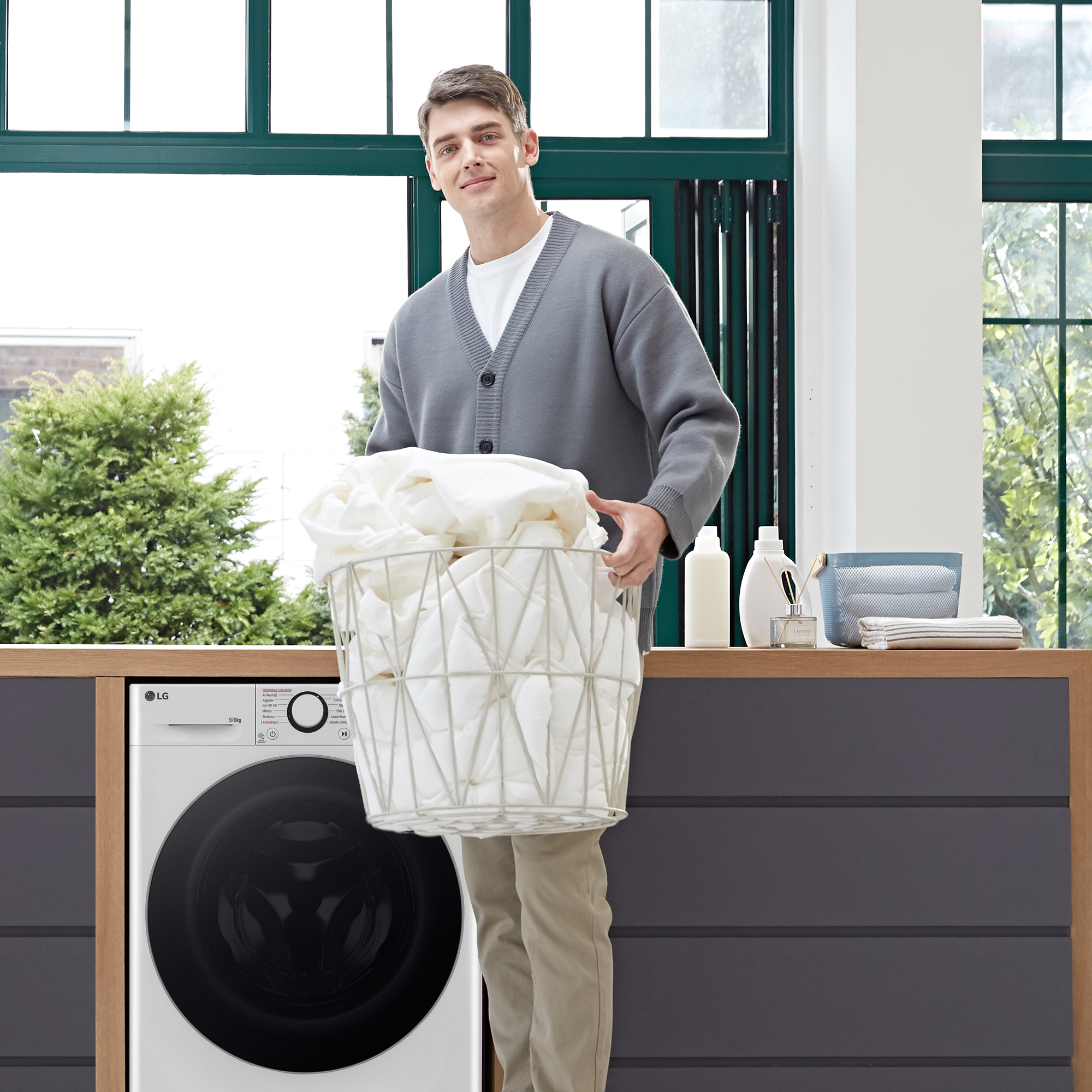 Hombre con cesta de ropa blanca en cuarto de lavado.