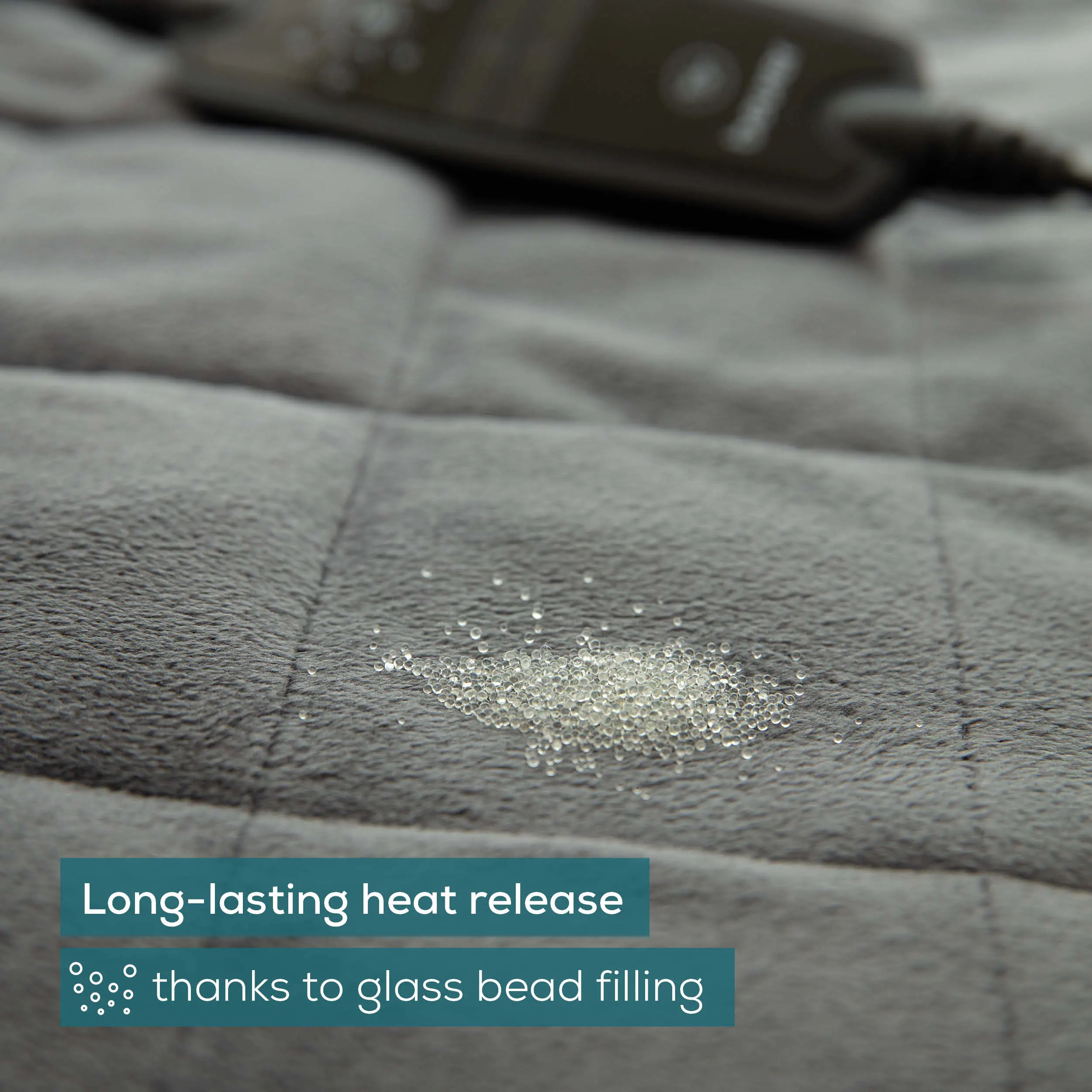 Una coperta riscaldata grigia con imbottitura in perline di vetro e testo sul rilascio del calore.