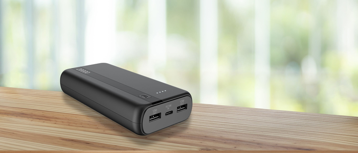 Powerbank mit USB-Anschlüssen auf einem Tisch.