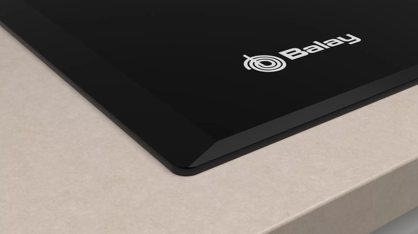 Encimera de vidrio negro con el logo de Balay en encimera beige claro.