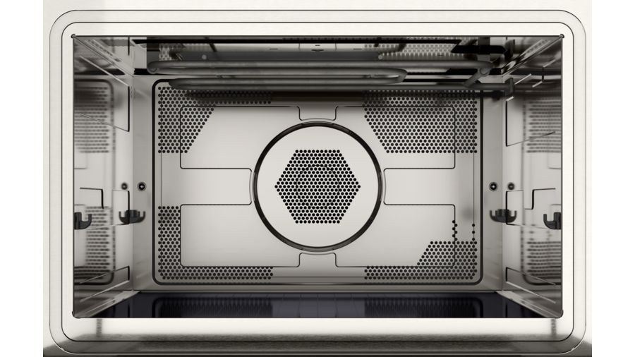 Interior de un horno de acero inoxidable. El interior es plateado con una parte trasera de metal perforado.