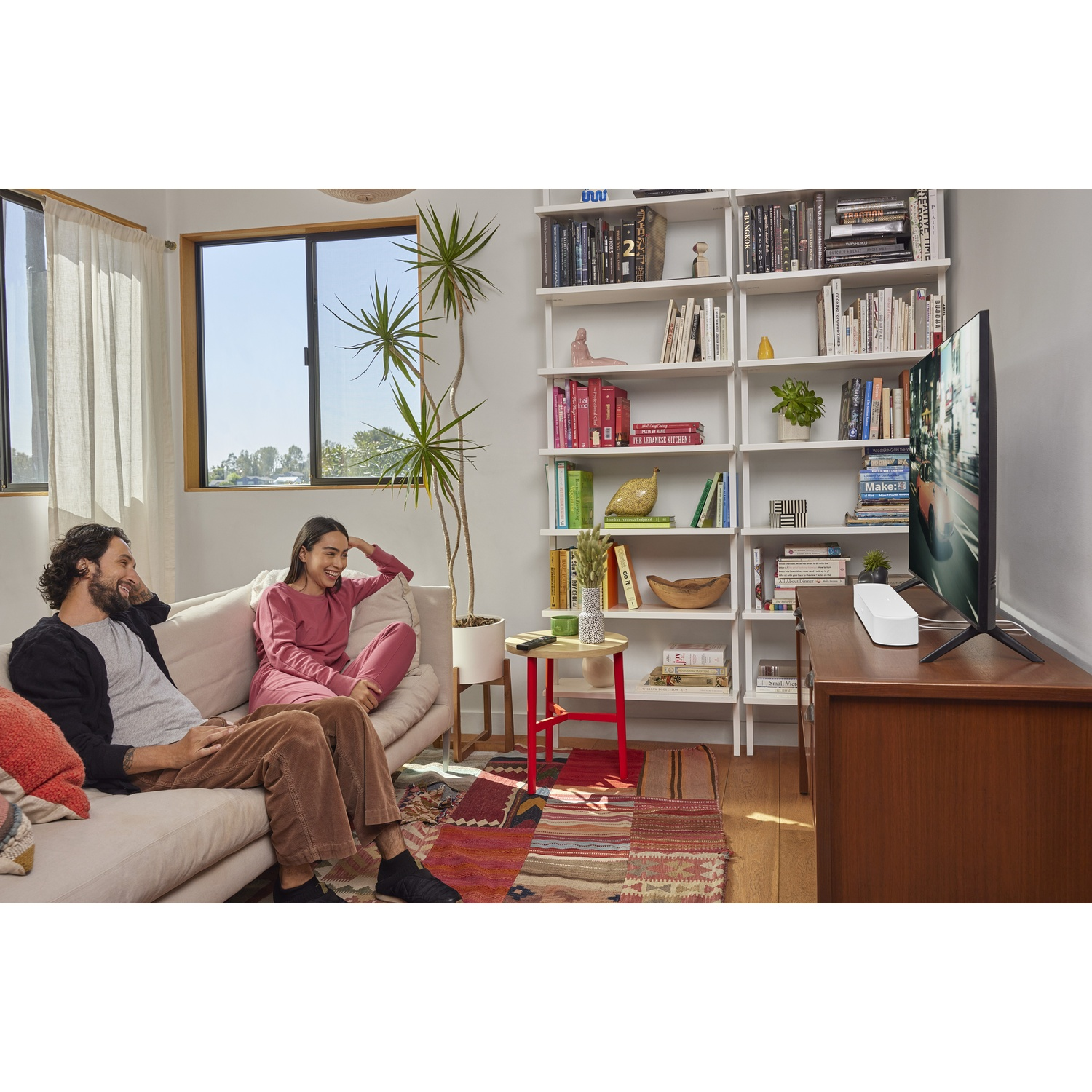 Due persone sono sedute su una panchina, guardando la TV.