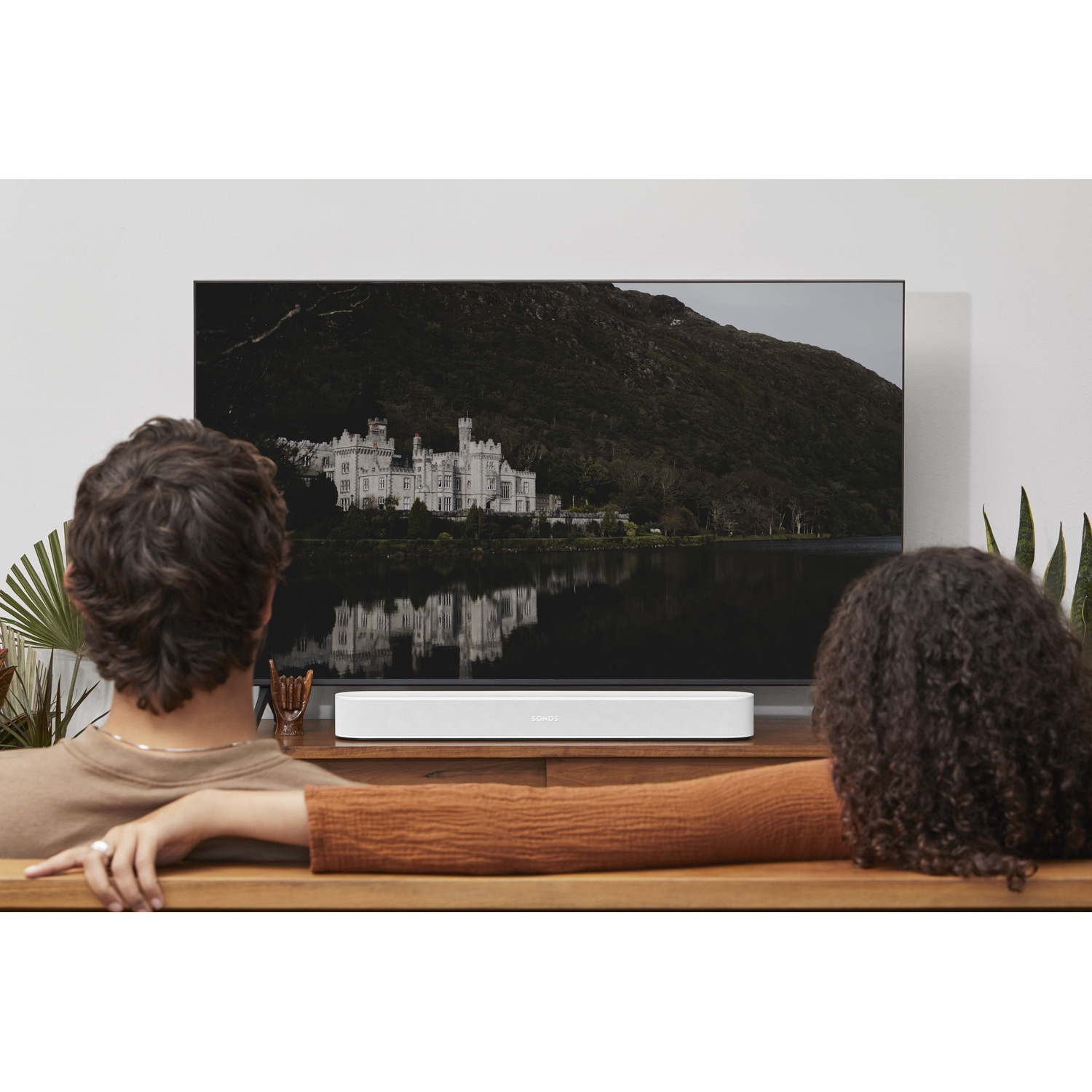 Una coppia seduta davanti a una TV su uno scaffale.