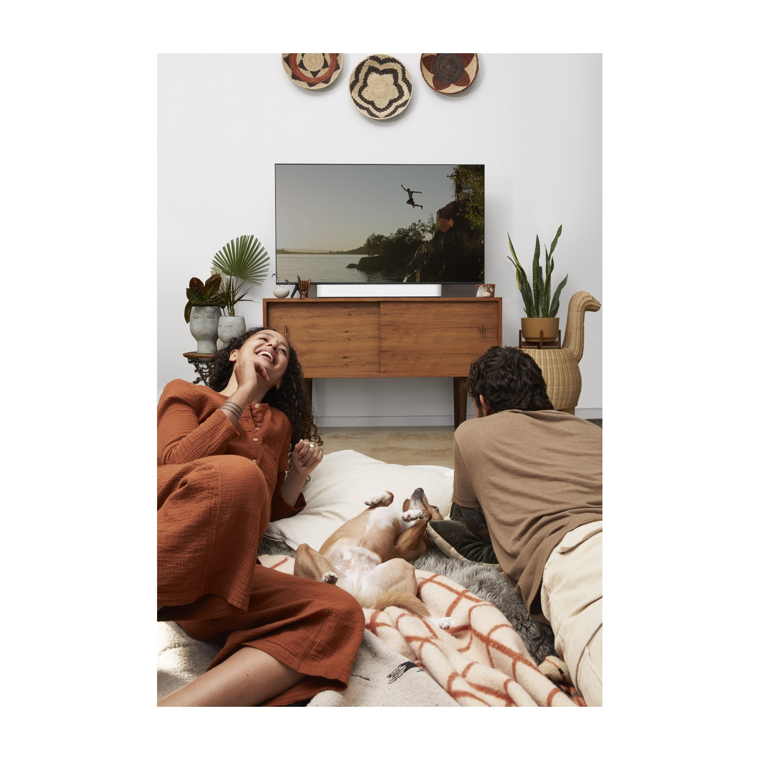 Una donna e un uomo sono per terra, guardando la TV.