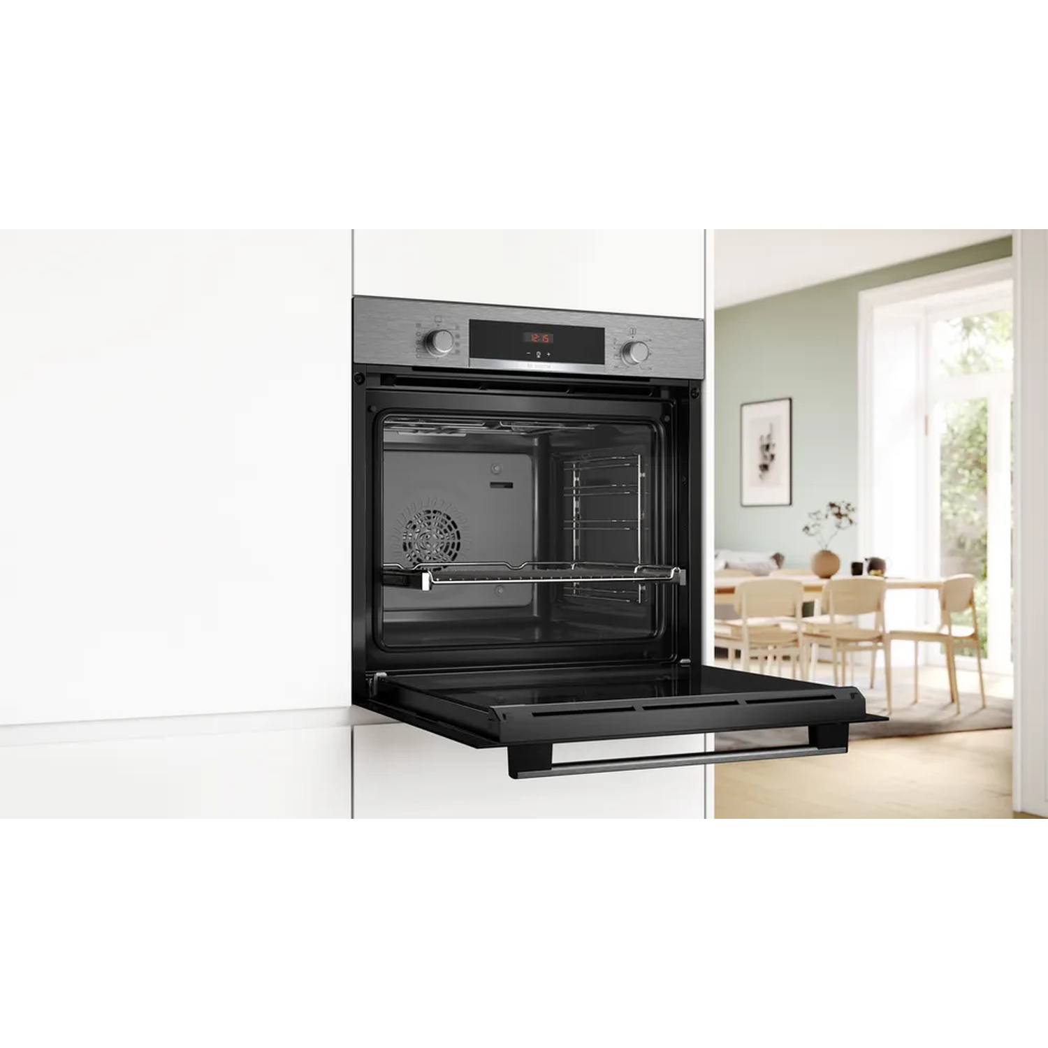 Forno aperto in un ambiente cucina, porta aperta. Interno in acciaio inossidabile, con griglia.