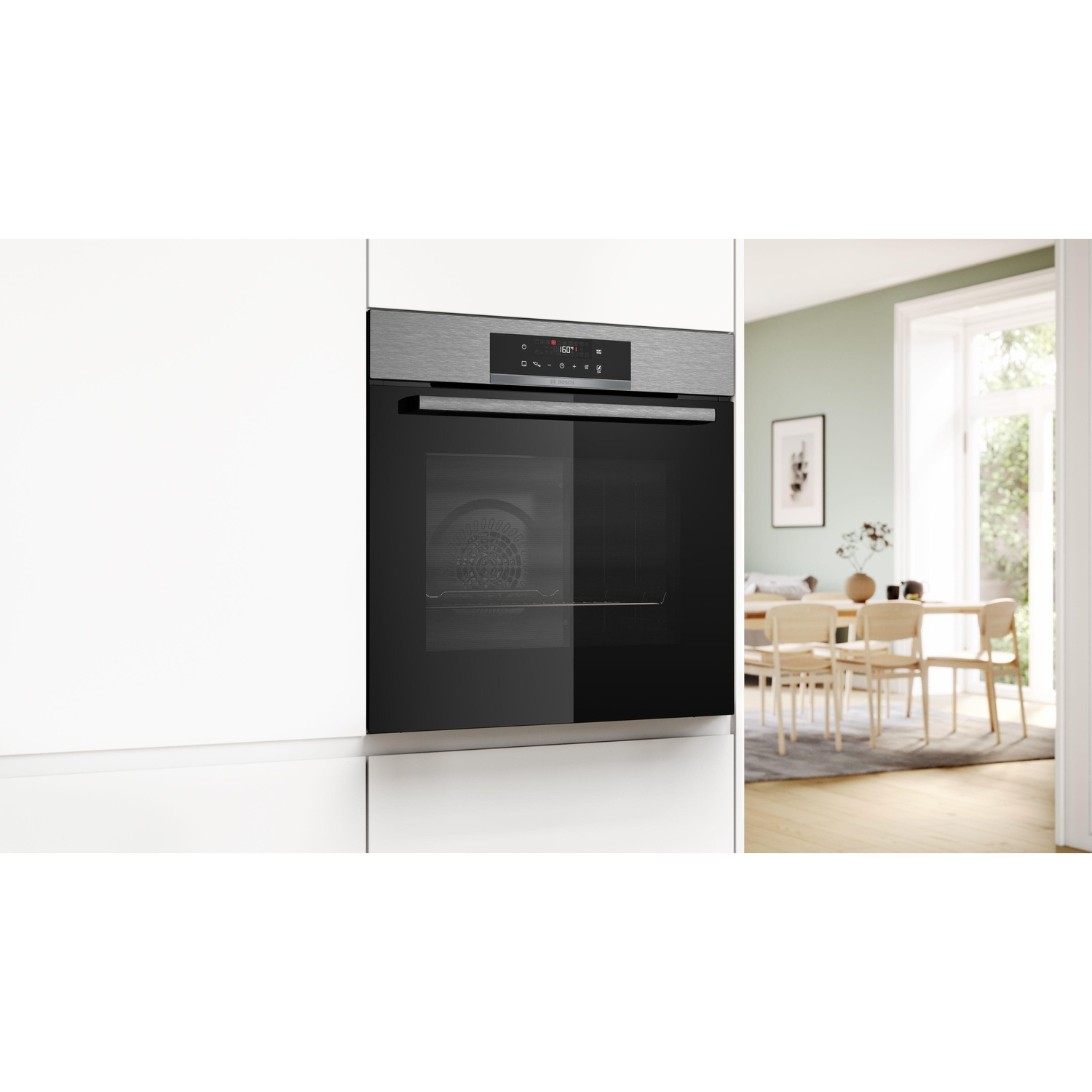 Forno integrato in un mobile bianco, con cucina e zona pranzo sullo sfondo.
