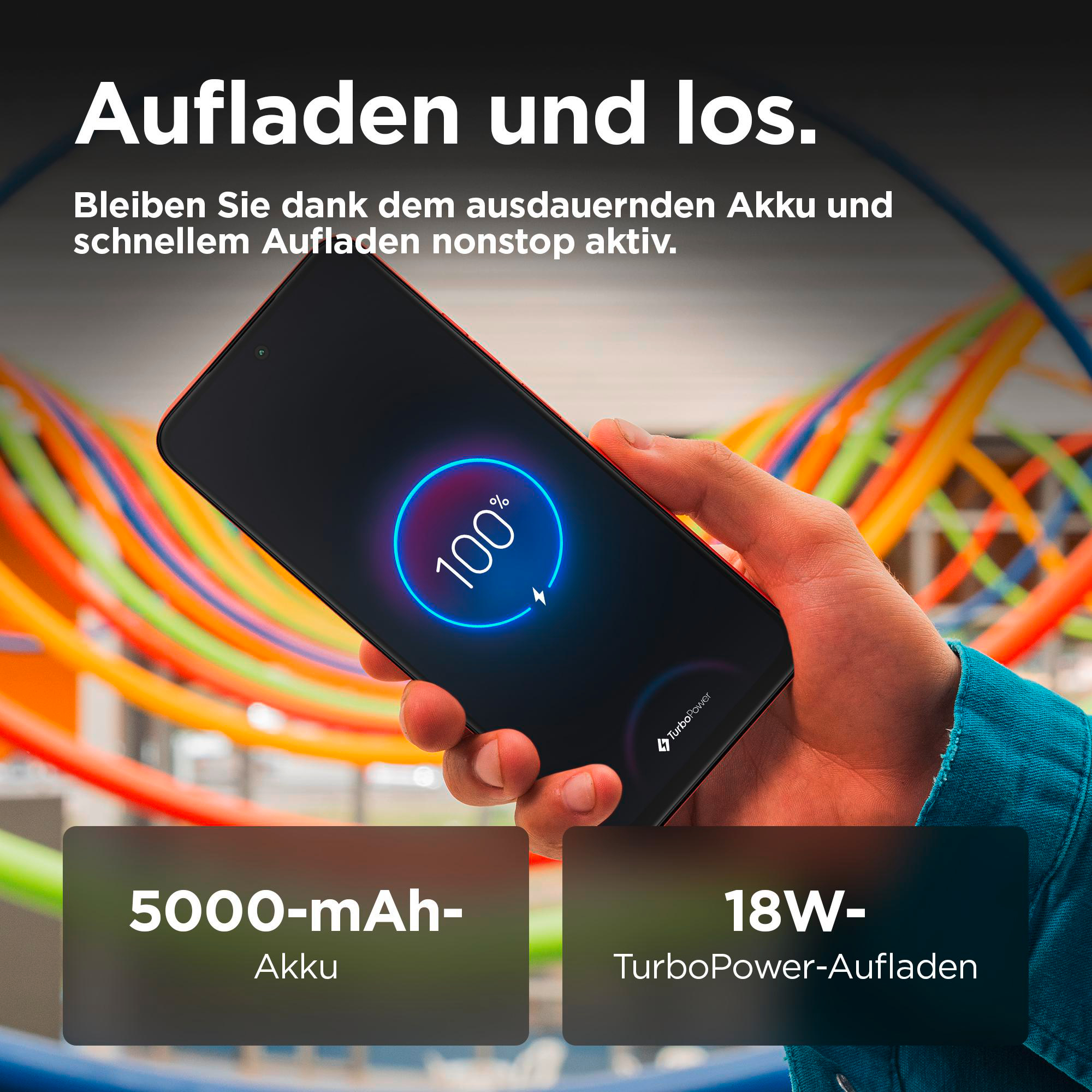 Hand hält Smartphone, das zu 100 % geladen wird. 5000 mAh Akku, 18W TurboPower Laden.