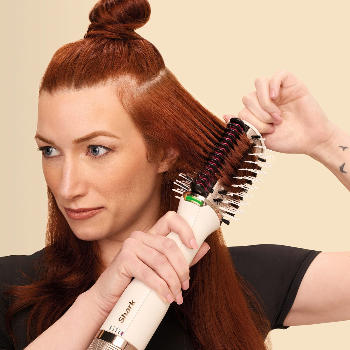 Donna che si acconcia i capelli rossi con una spazzola arricciacapelli. Capelli rossi sezionati e acconciati.
