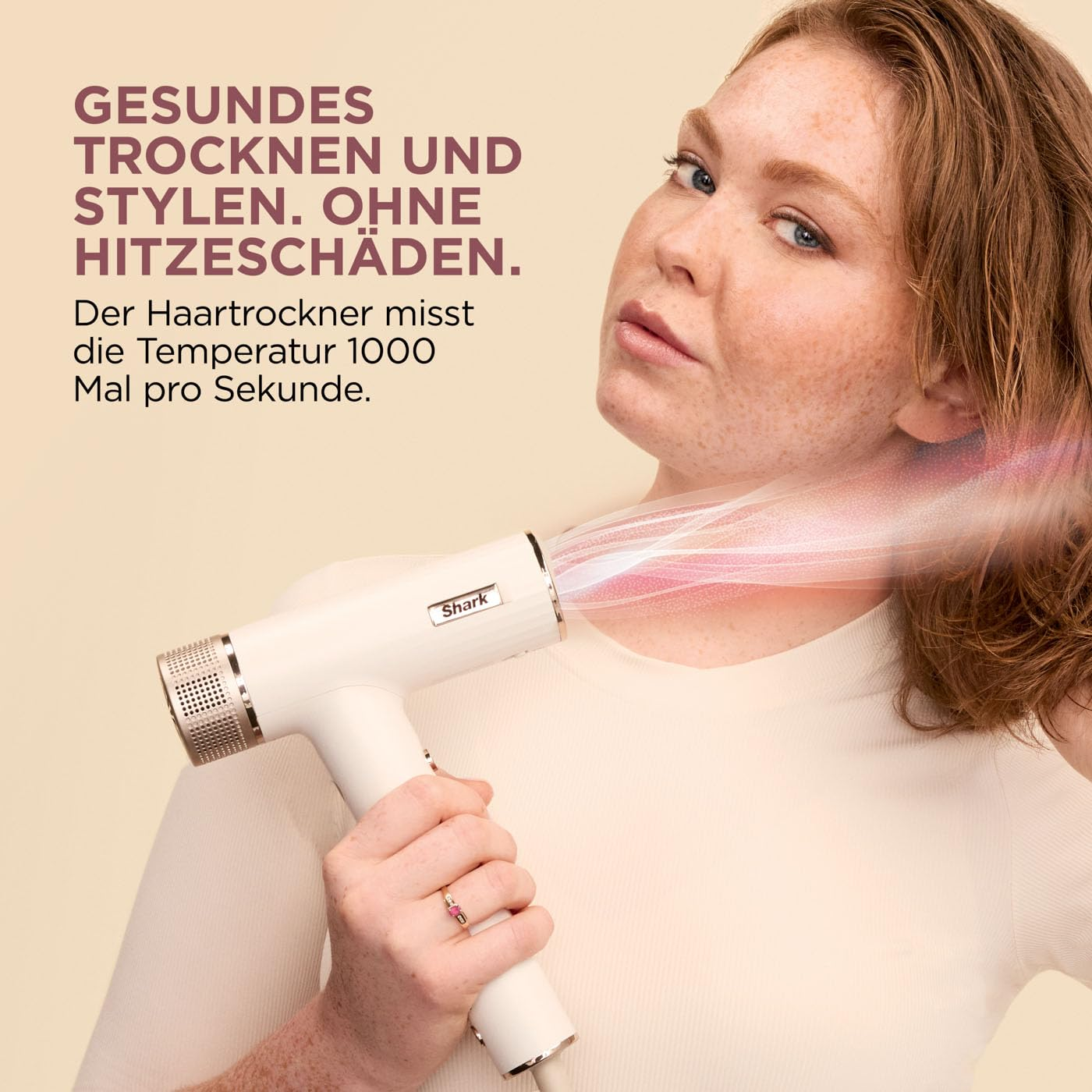 Femme utilise un sèche-cheveux blanc Shark. Texte : Séchage et coiffage sains. Sans abîmer les cheveux.