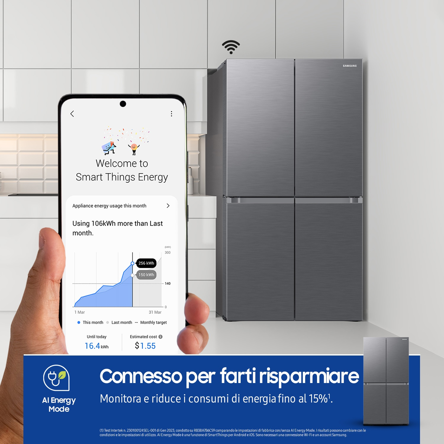 Una persona tiene in mano un telefono che mostra i dati di consumo, con un frigorifero sullo sfondo.
