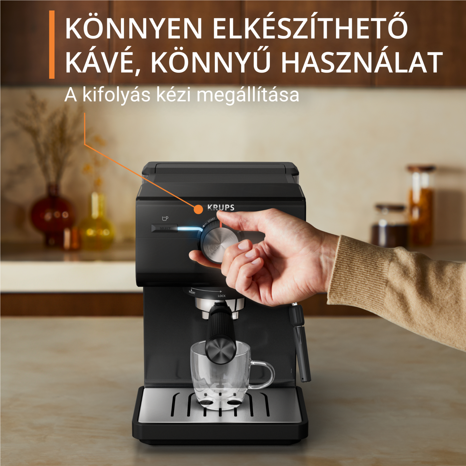 Egy személy keze egy fekete eszpresszógép tárcsáját forgatja. Szöveg: Könnyen elkészíthető kávé. Könnyen használható.