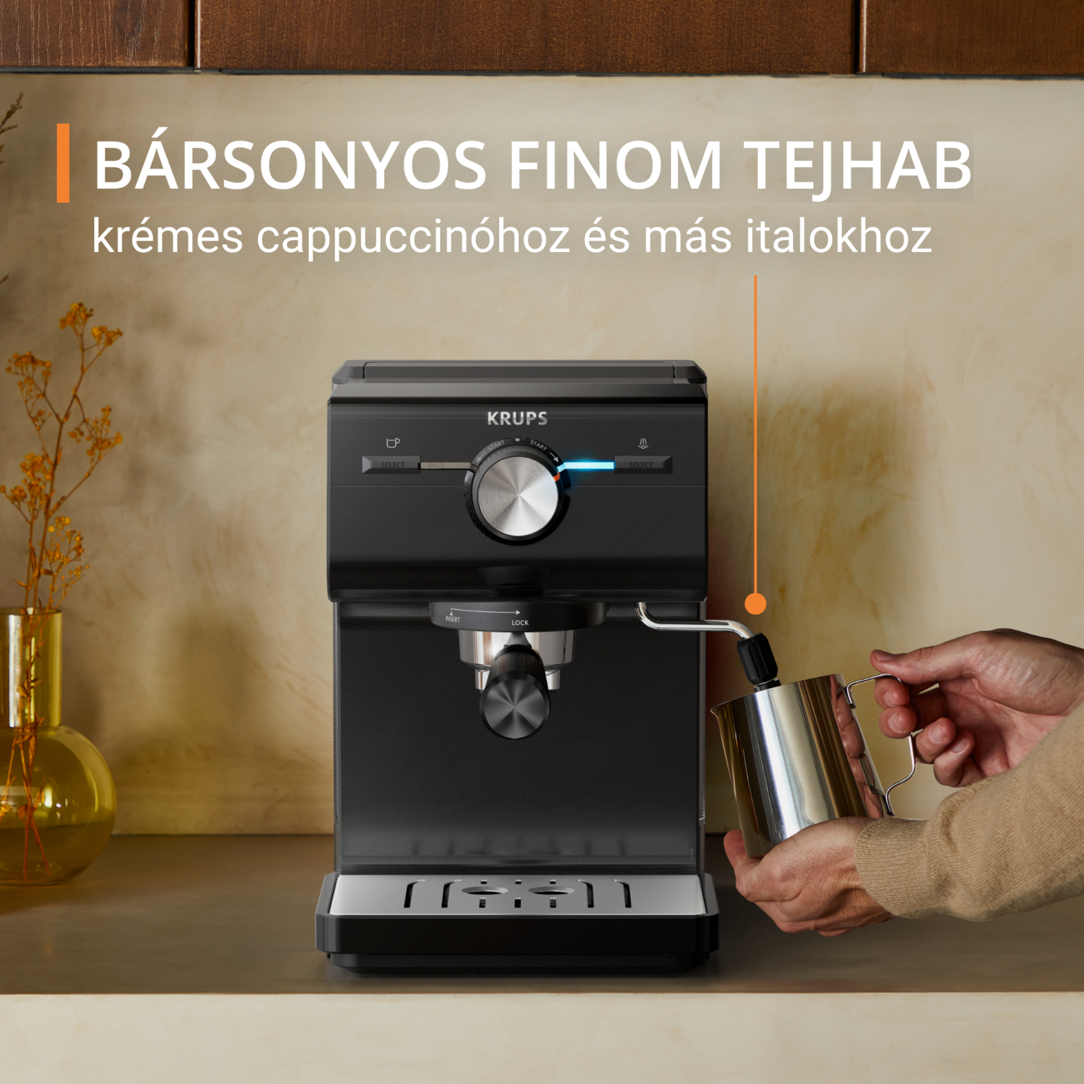 Fekete eszpresszógép, egy személy tejet önt egy fém kancsóba. Szöveg: krémes cappuccino.