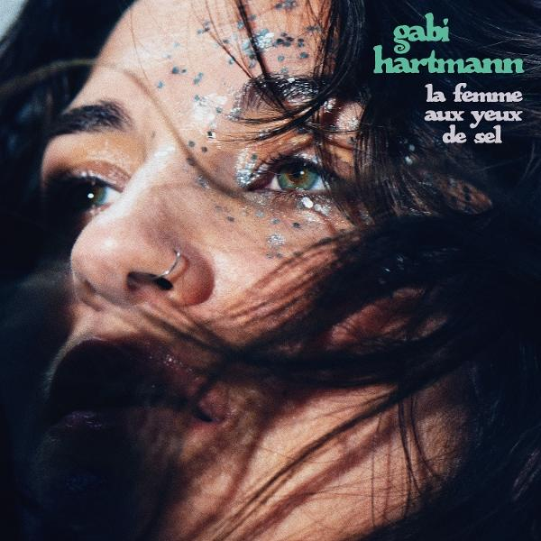 Nahaufnahme eines Frauen-Gesichts mit Glitzer und Text: gabi hartmann la femme aux yeux de sel.