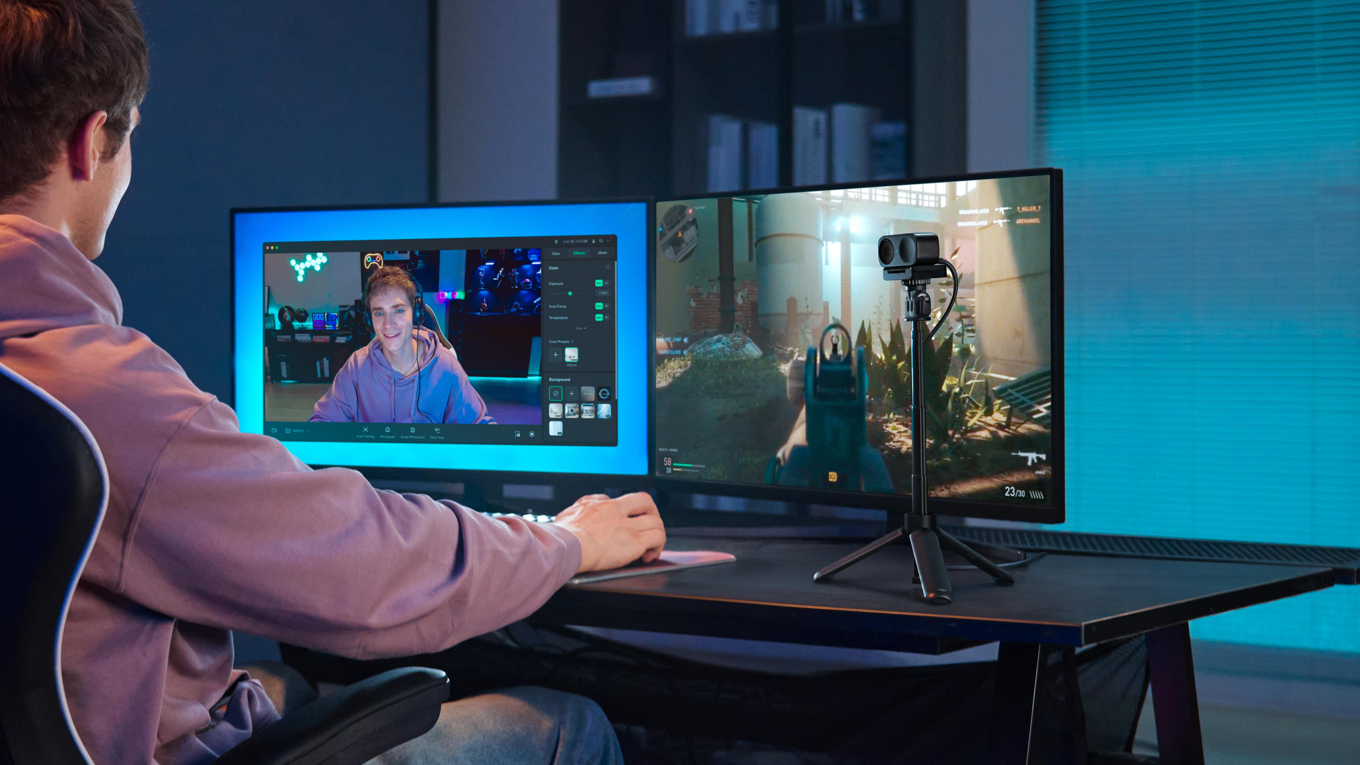 Gamer spielt auf zwei Monitoren, Webcam auf Stativ, Streaming-Setup.