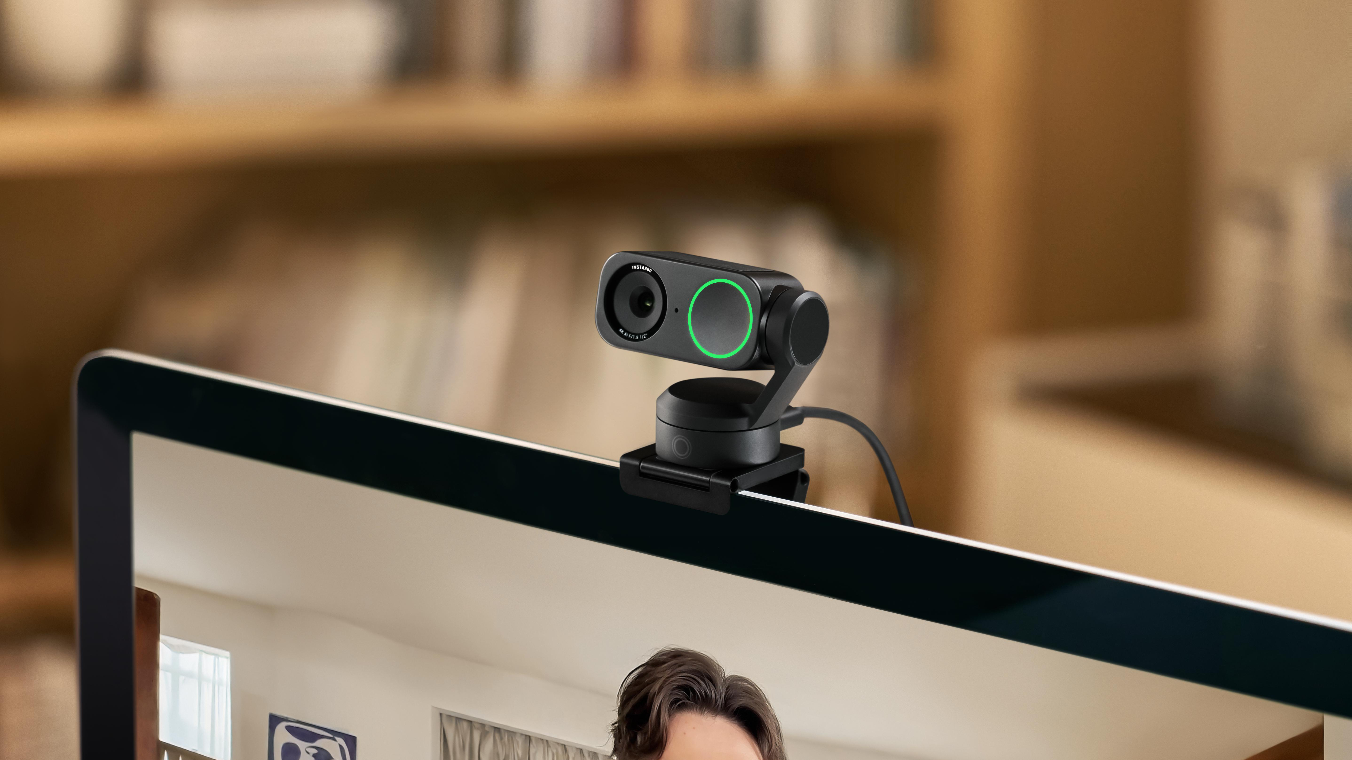 Webcam auf einem Monitor mit Gesicht im Hintergrund, grünes Licht.