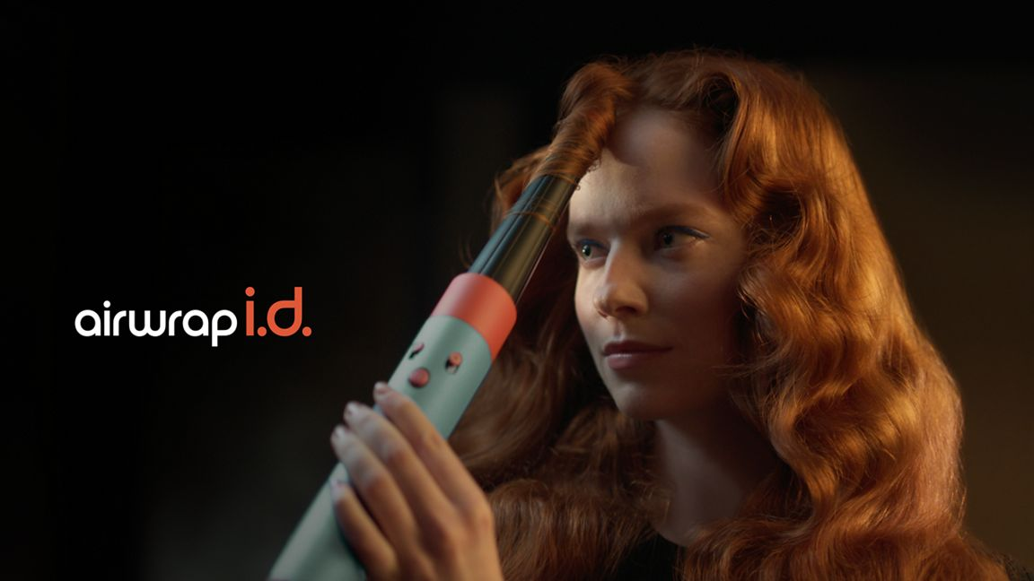 Donna con i capelli rossi che usa un arricciacapelli sui capelli