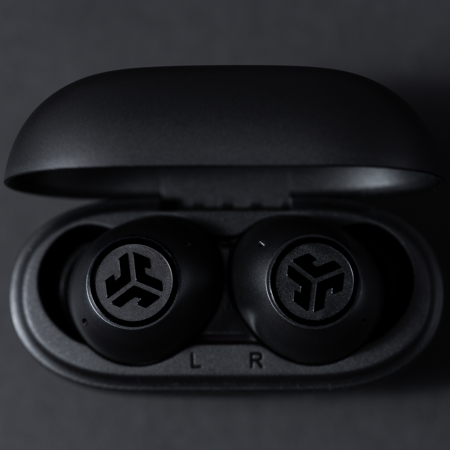 Black earbuds in a black case. The case is open.