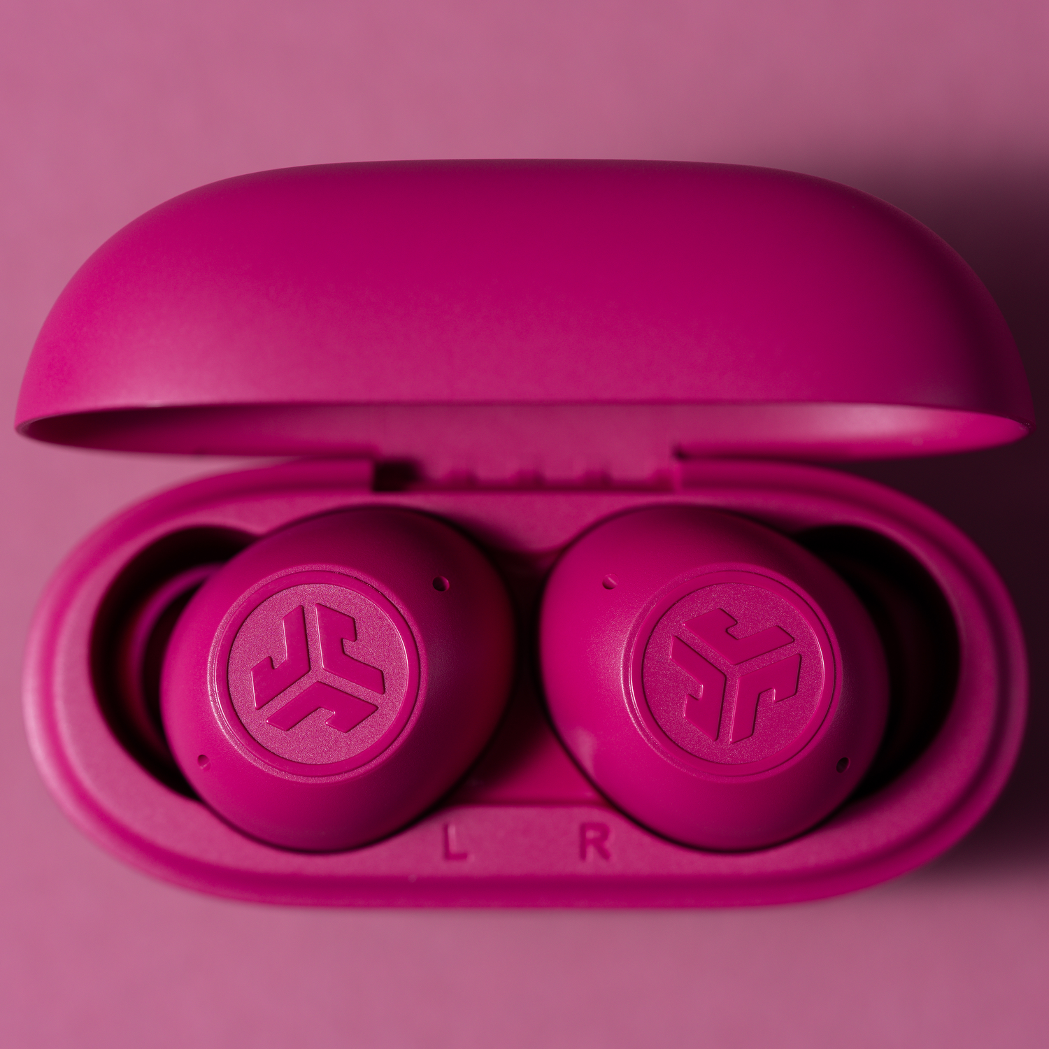 Open pink earbuds case with two earbuds inside.