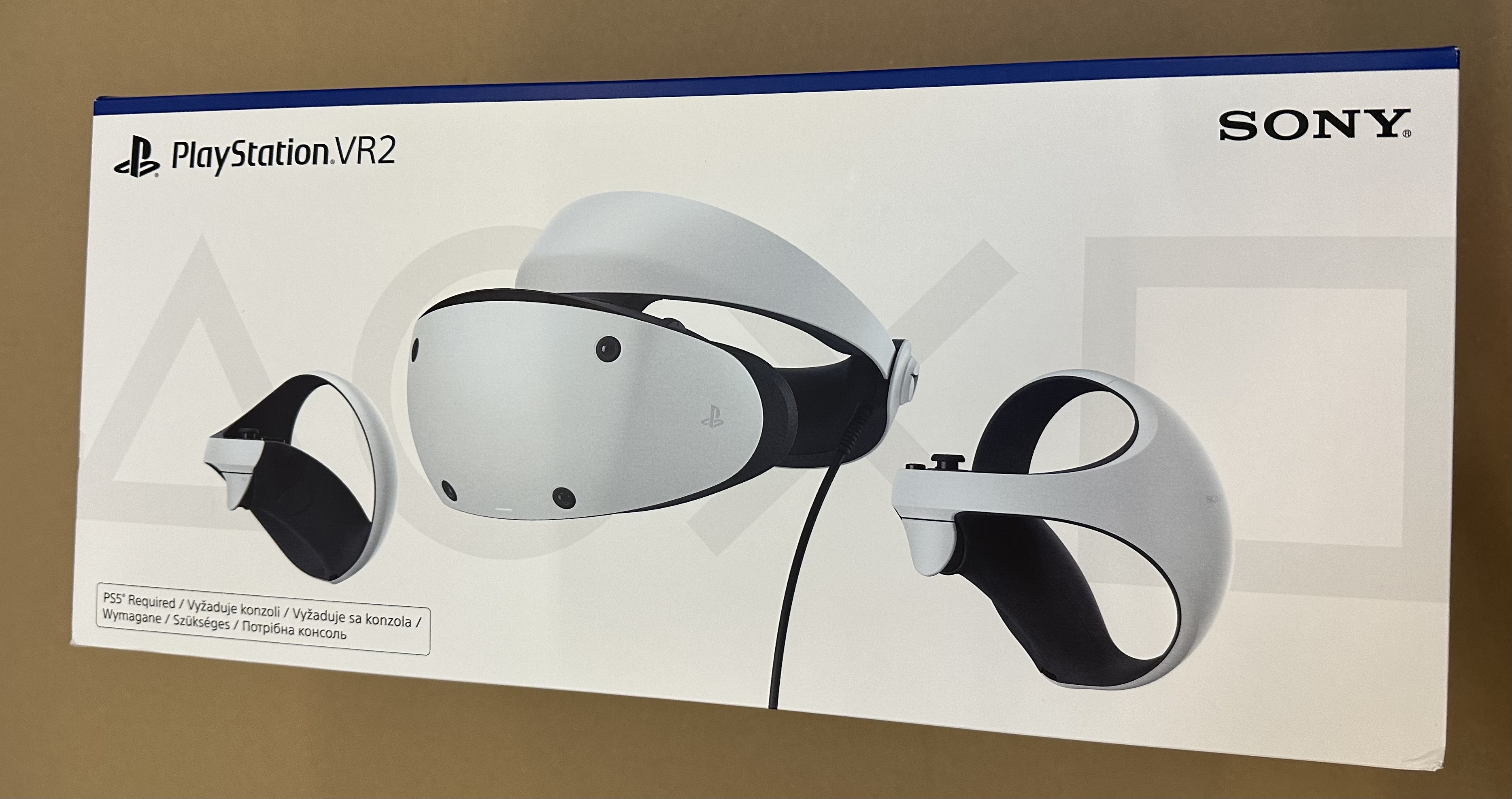 Biały zestaw Playstation VR2 i kontrolery są wyświetlane w białym pudełku.