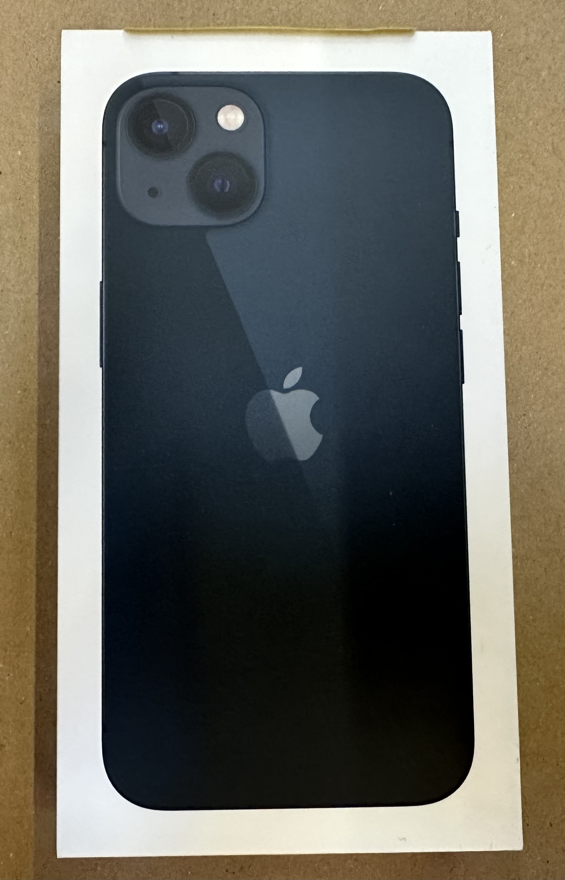 Czarny iPhone 13 z podwójnym systemem kamer na białym pudełku.