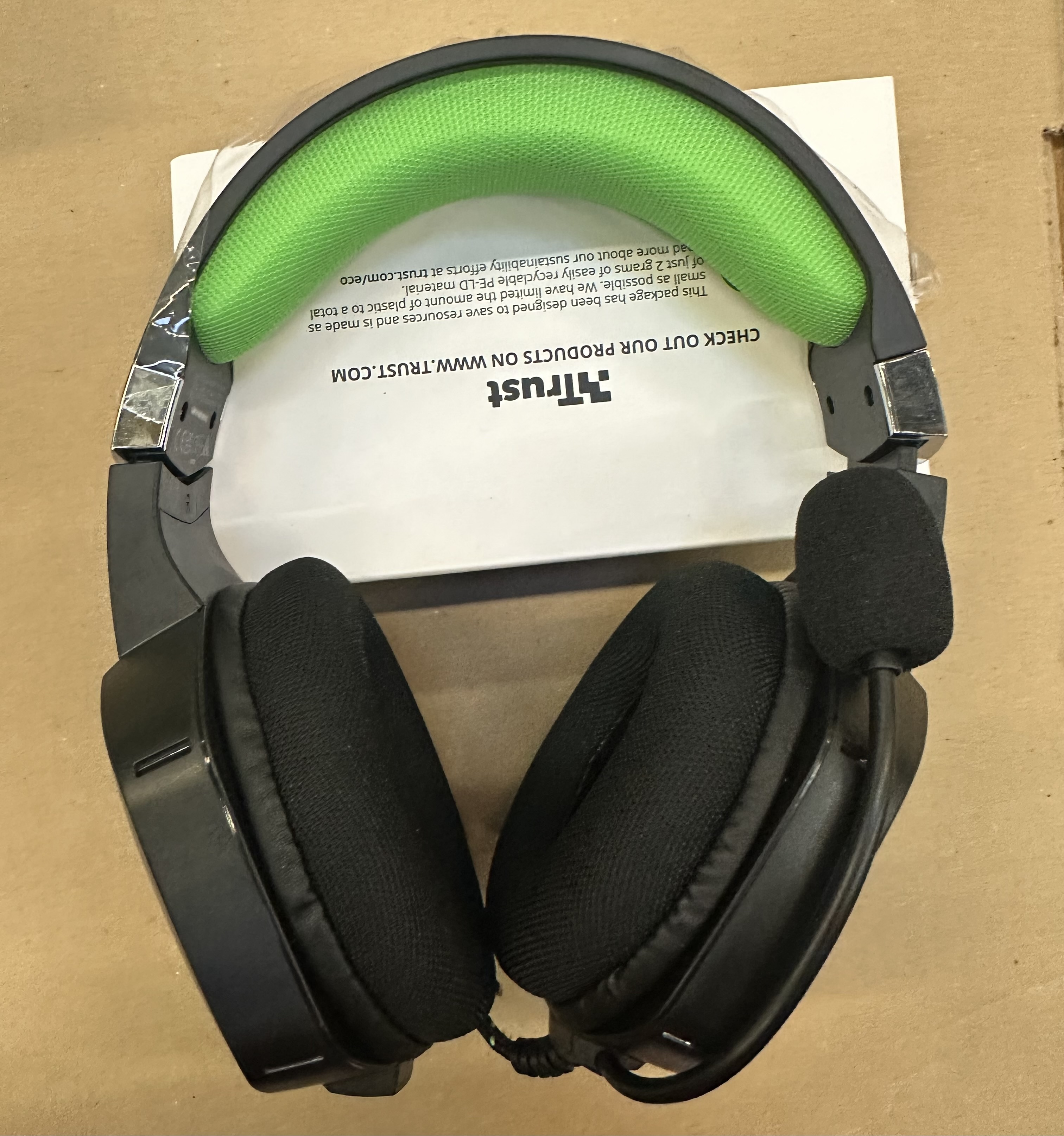 Czarny i szary zestaw słuchawkowy z zieloną wyściółką, przewodem i mikrofonem.