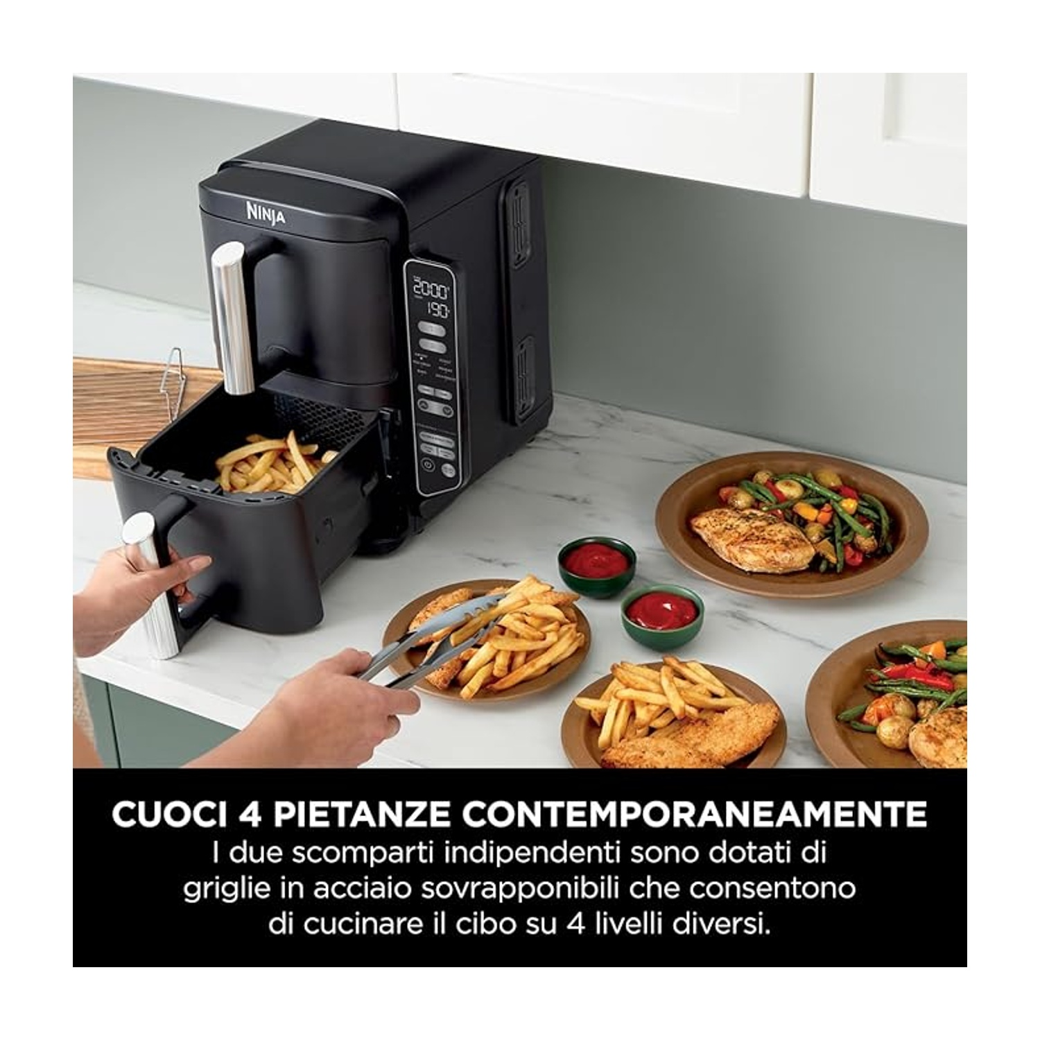 Friggitrice ad aria nera con cestello di patatine fritte aperto. Piatti con cibo e ciotole di salsa sul bancone.