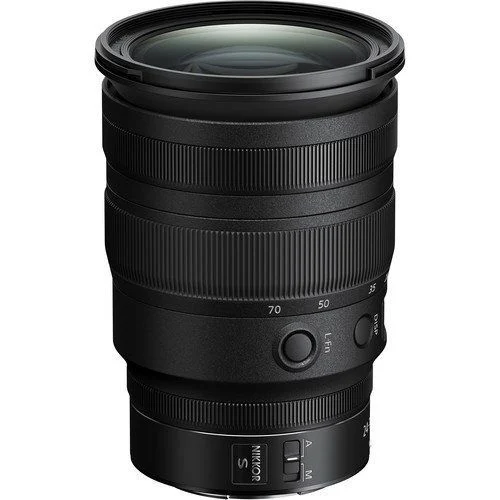 Siyah Nikon kamera lensi, odak uzaklığı gibi detayları gösteriyor. Odak halkası ve çeşitli düğmeleri var.