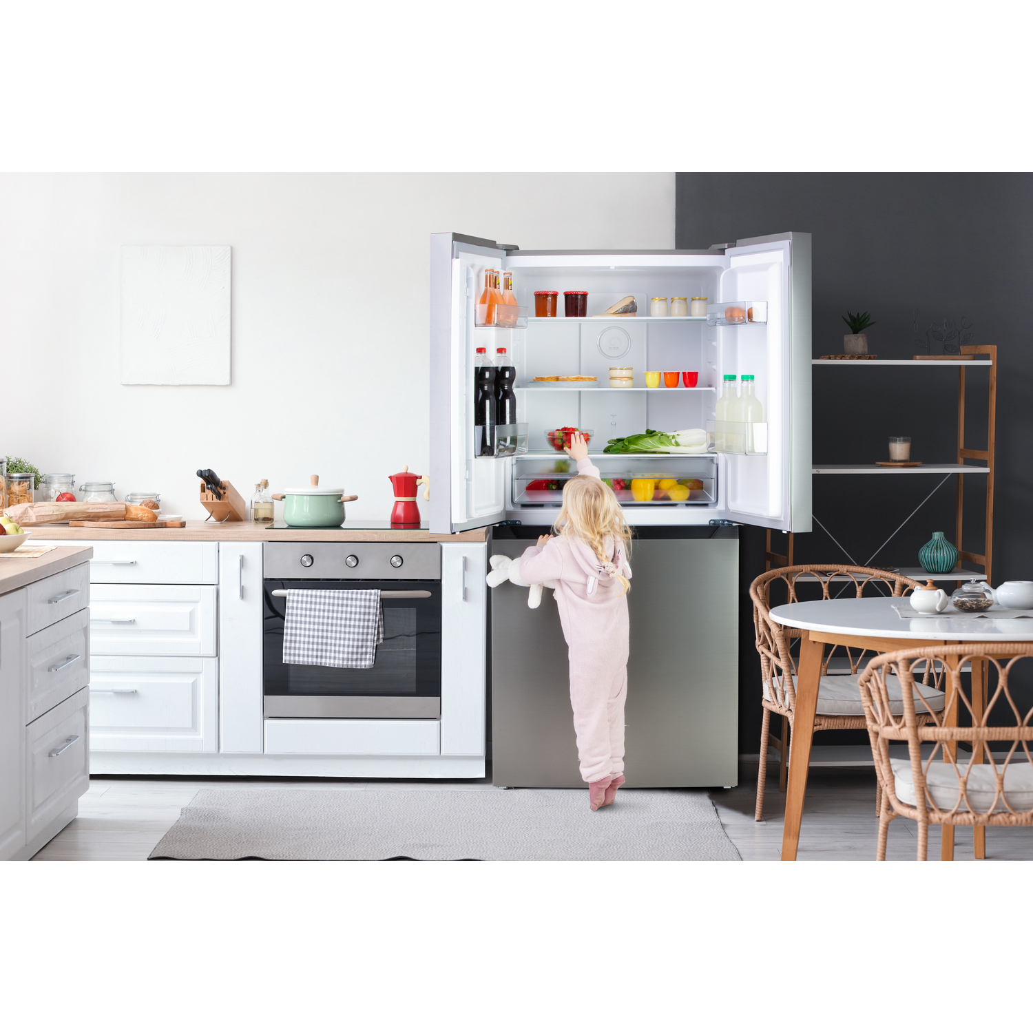 A young girl reaches into an open refrigerator.