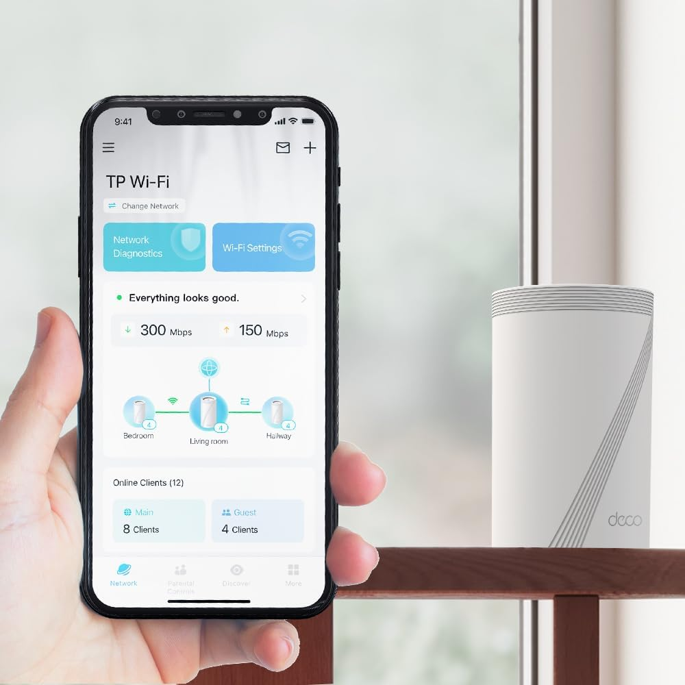 Ein Smartphone zeigt eine TP-Link Wi-Fi-Oberfläche, mit einem Router auf einem Holzregal.