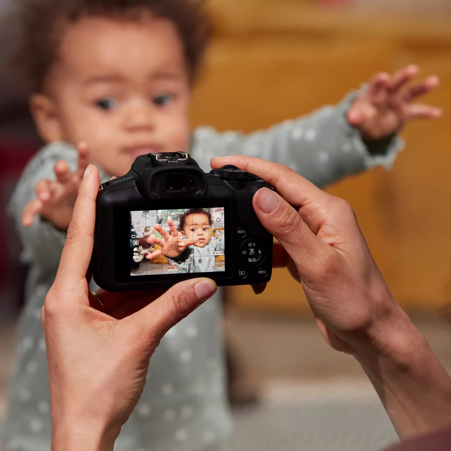 Eine Person hält eine Kamera, die das Gesicht eines Babys auf dem Bildschirm zeigt.