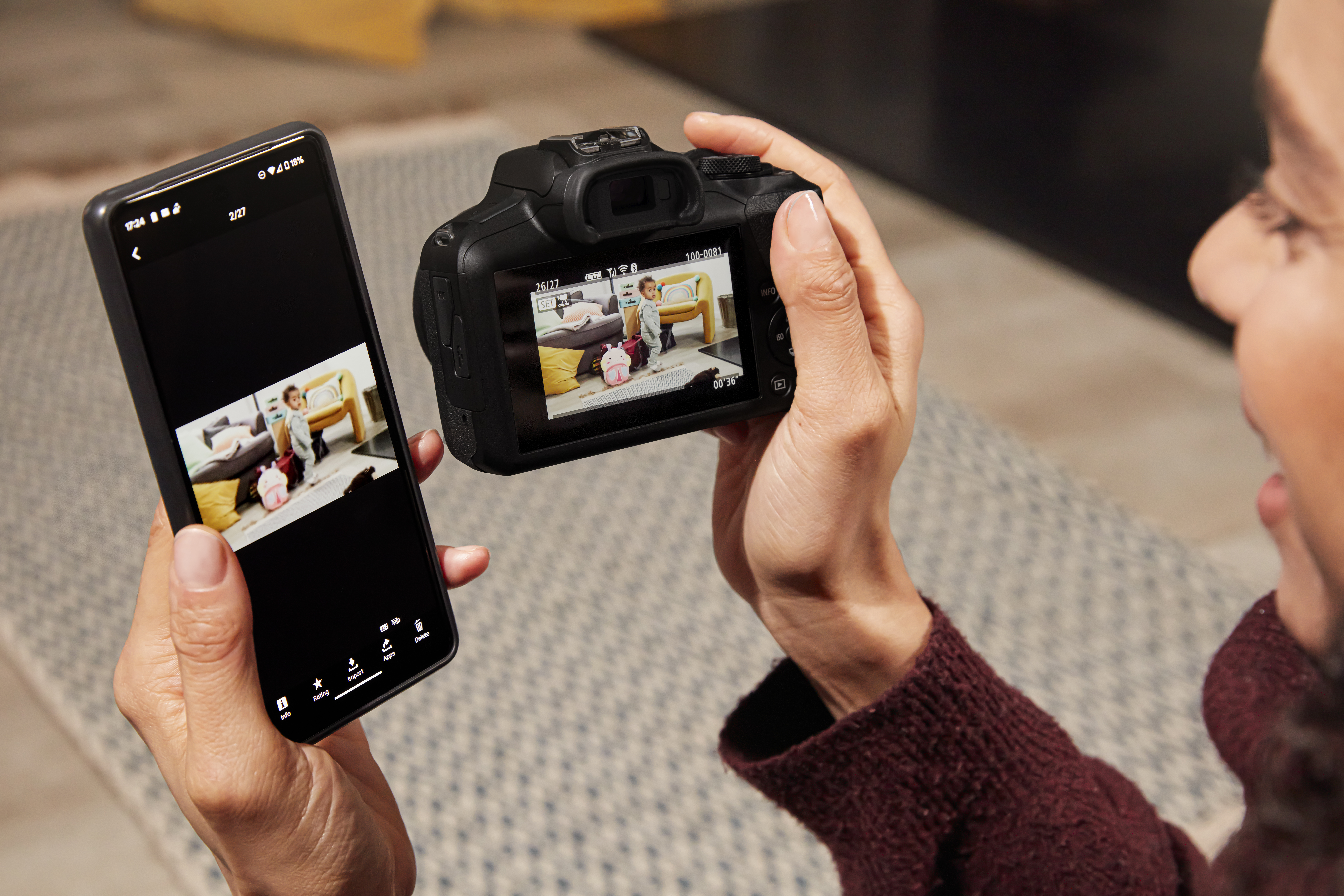 Frau hält Kamera und Telefon. Kamera rechts zeigt Foto auf dem Bildschirm.