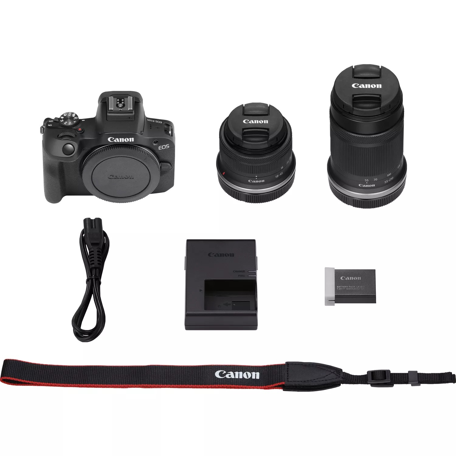 Ein Kamera-Kit mit Kamera, Objektiven, Ladegerät, Akku und Gurt auf weißem Hintergrund.