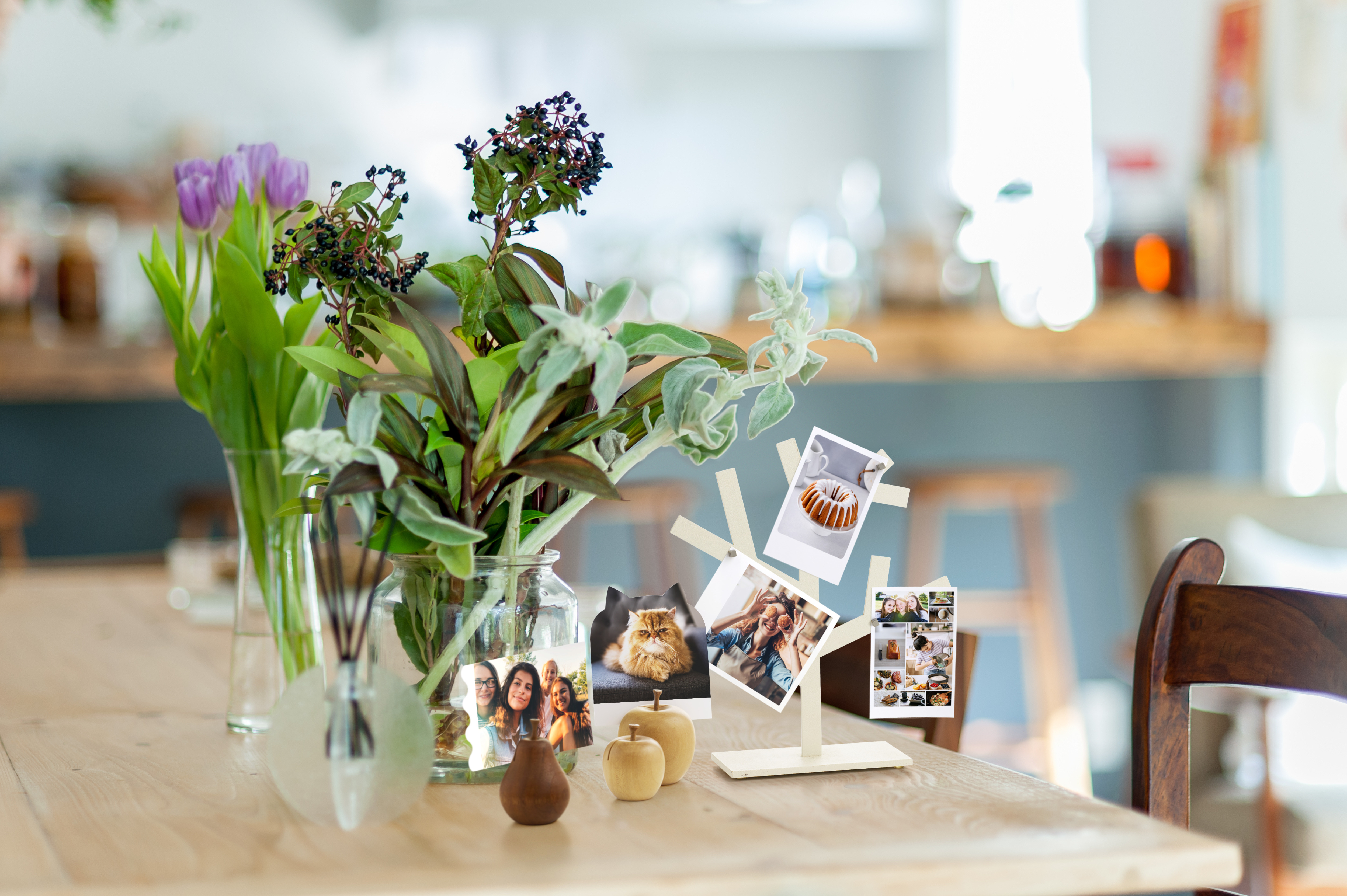 Tisch mit Blumen, Fotos und dekorativen Gegenständen.