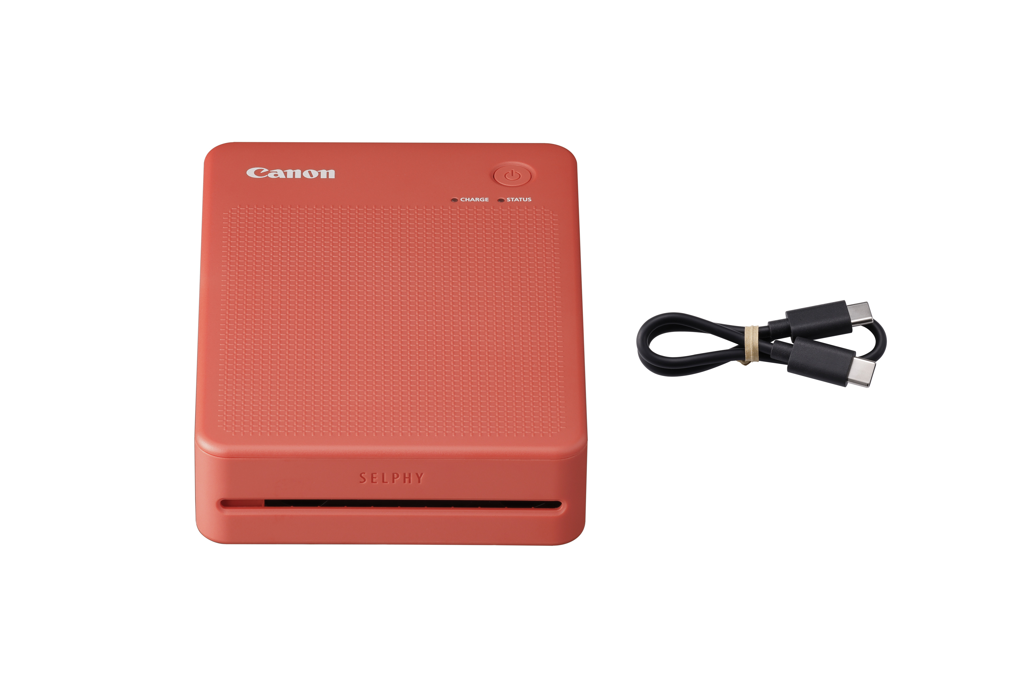 Roter Canon Selphy-Drucker mit schwarzem USB-Kabel. Weißer Hintergrund.