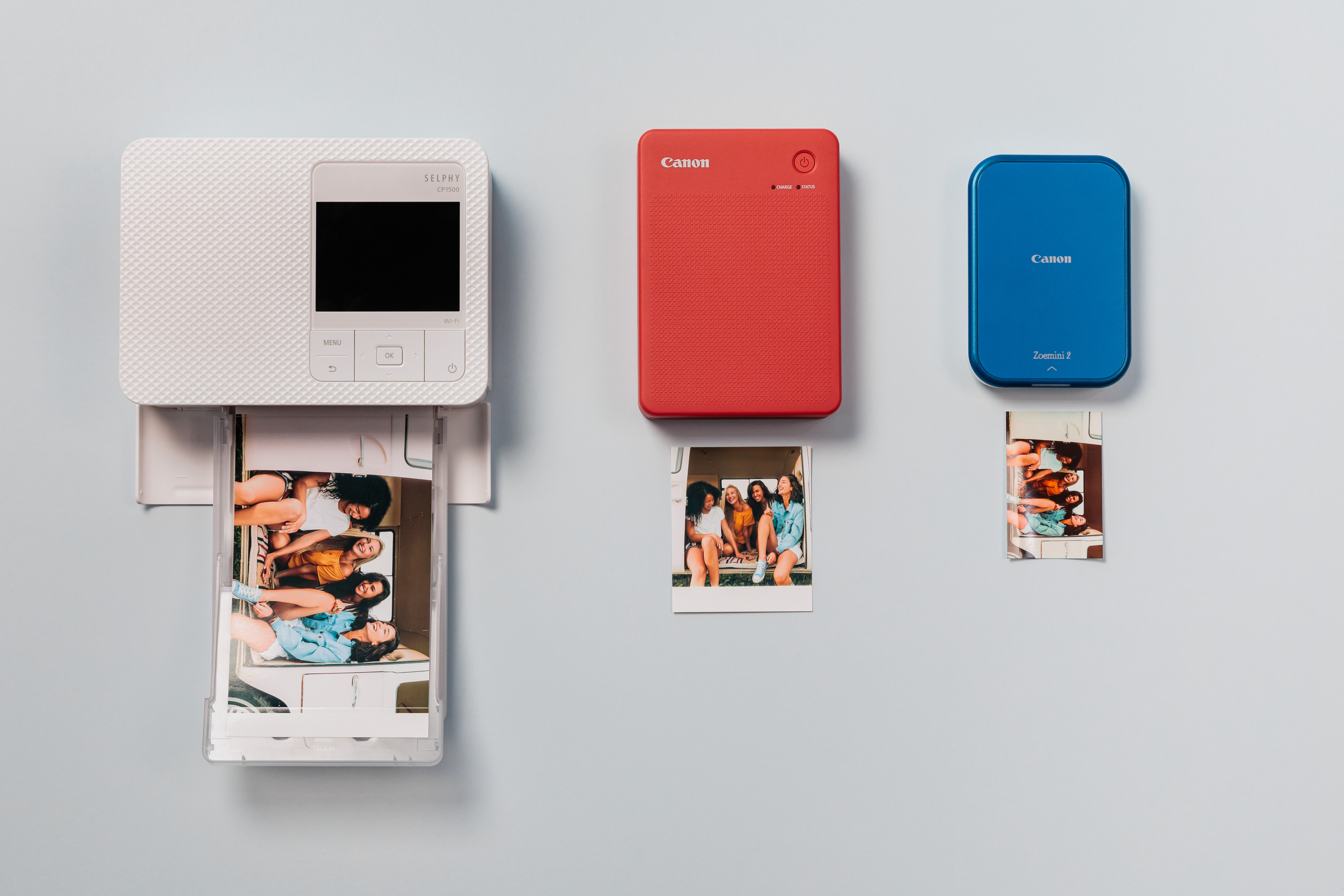 Drei Canon-Drucker und Fotos. Weißer Drucker druckt ein Foto.